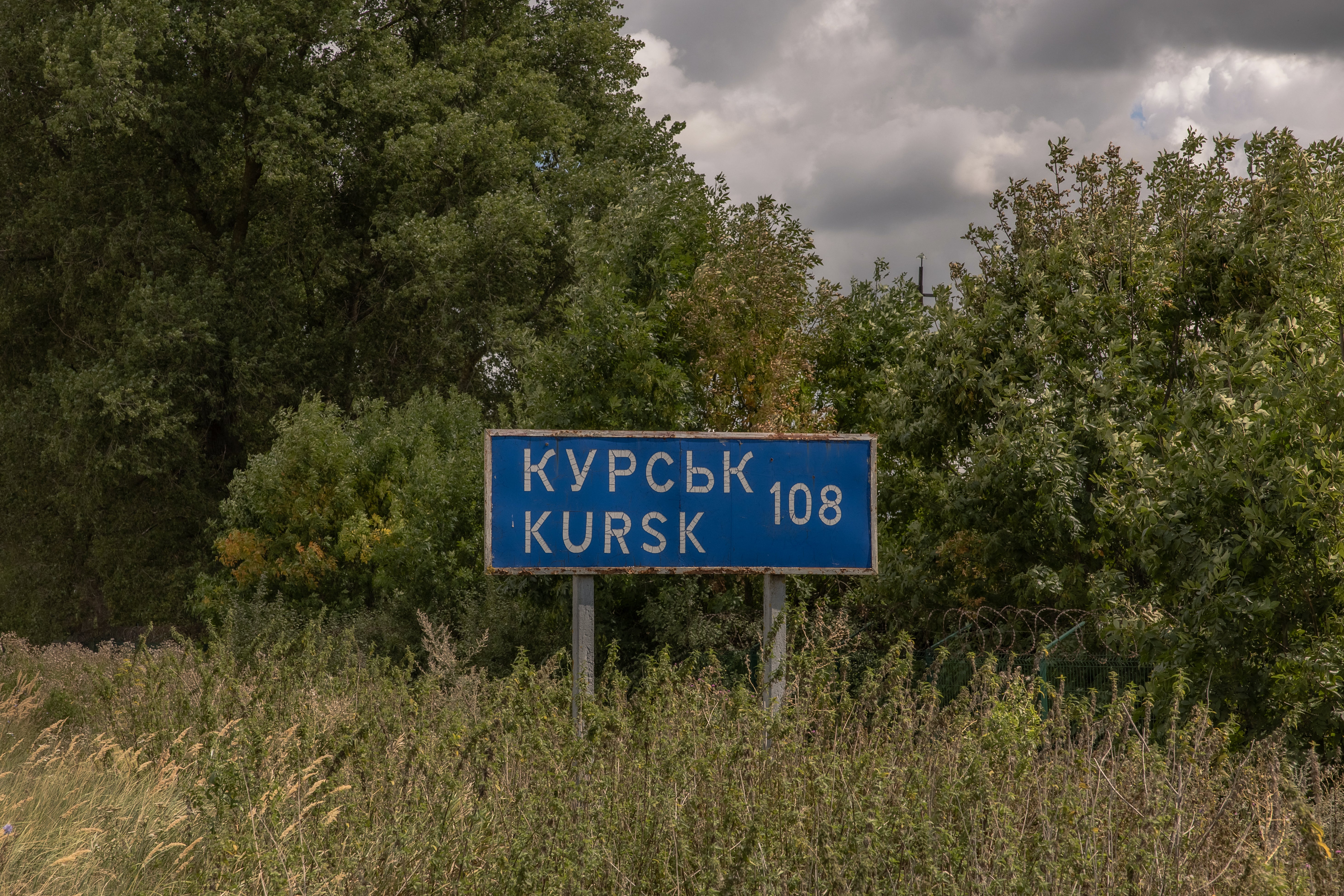 A road sign showing the distance to the Russian town of Kursk next to the destroyed border crossing point with Russia