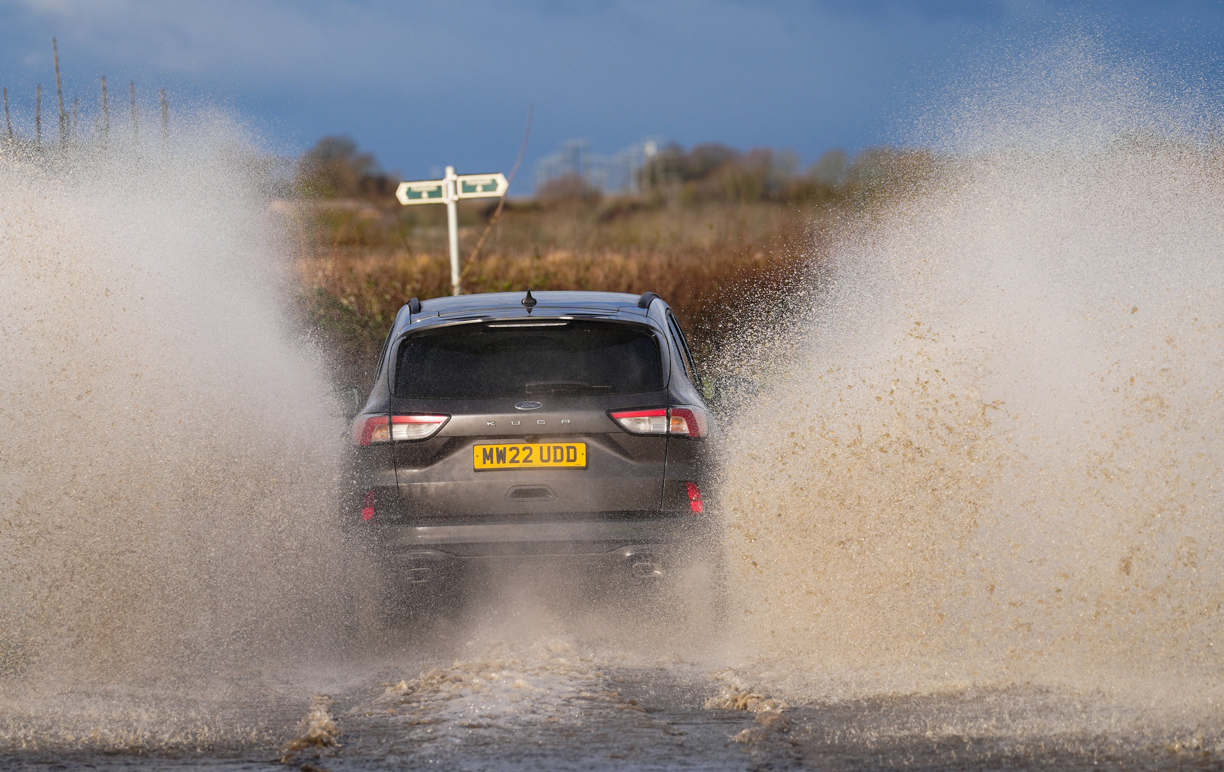 A vehicles drives through standing flood water near Eckington in Worcestershire, following snow and rain over the weekend