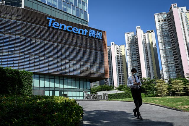 <p>Man walks past Tencent headquarters in Shenzhen, China </p>