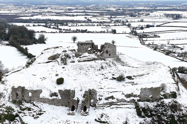 People walk in the snow at the Rock of Dunamase in Co Laois in Ireland (Niall Carson/PA)