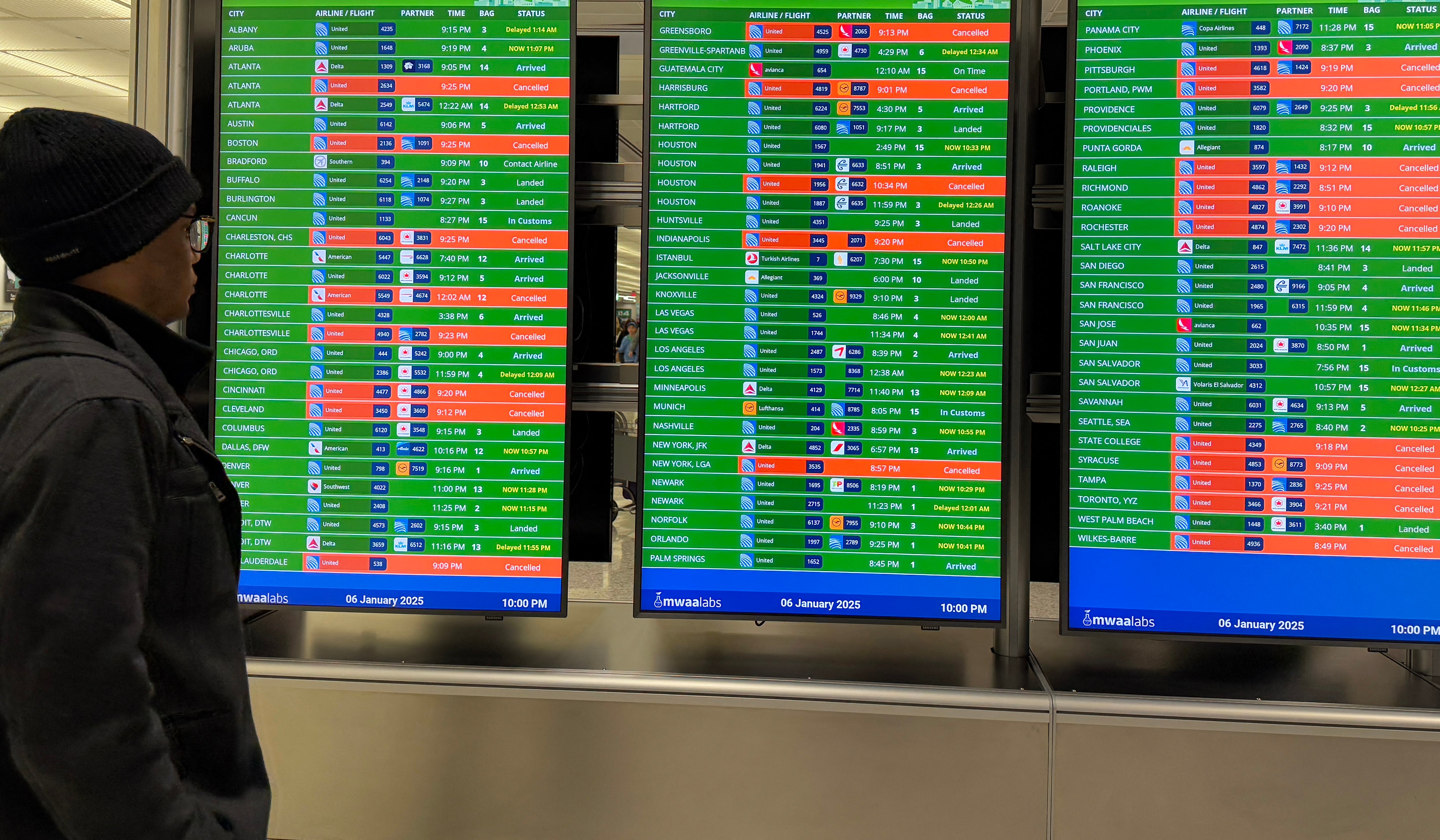 A man checks a flight information display showing many canceled flights at Virginia’s Washington Dulles International airport on Monday. After thousands of flight cancellations and delays were reported across states affected by a deadly winter storm in the eastern U.S., wintry weather has its eye on Texas and the South