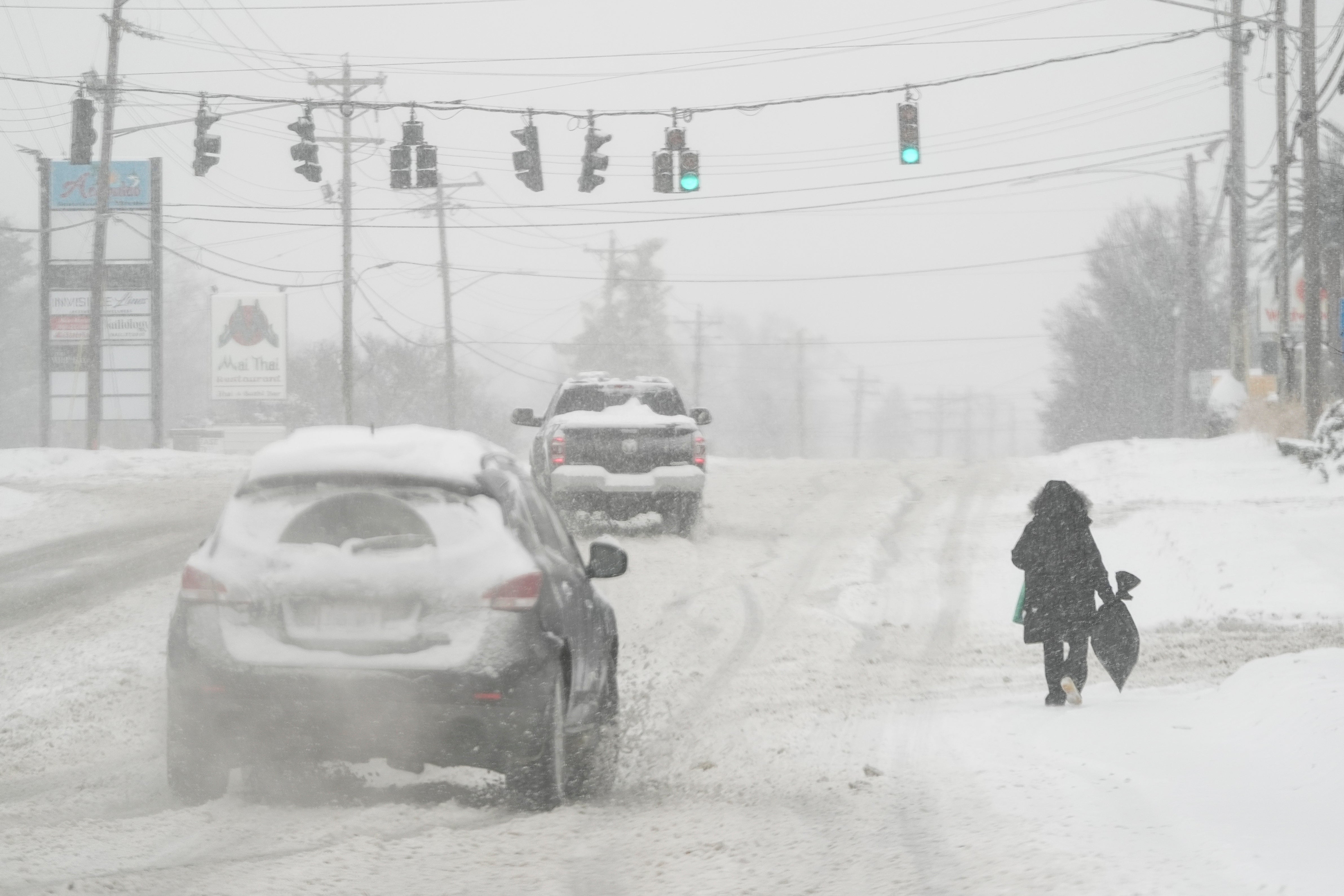 Heavy snow falls as a person walks along U.S. Route 42 in Florence, Kentucky, on Monday. More wintry weather conditions are forecast in Texas this week after storms resulted in hundreds of crashes