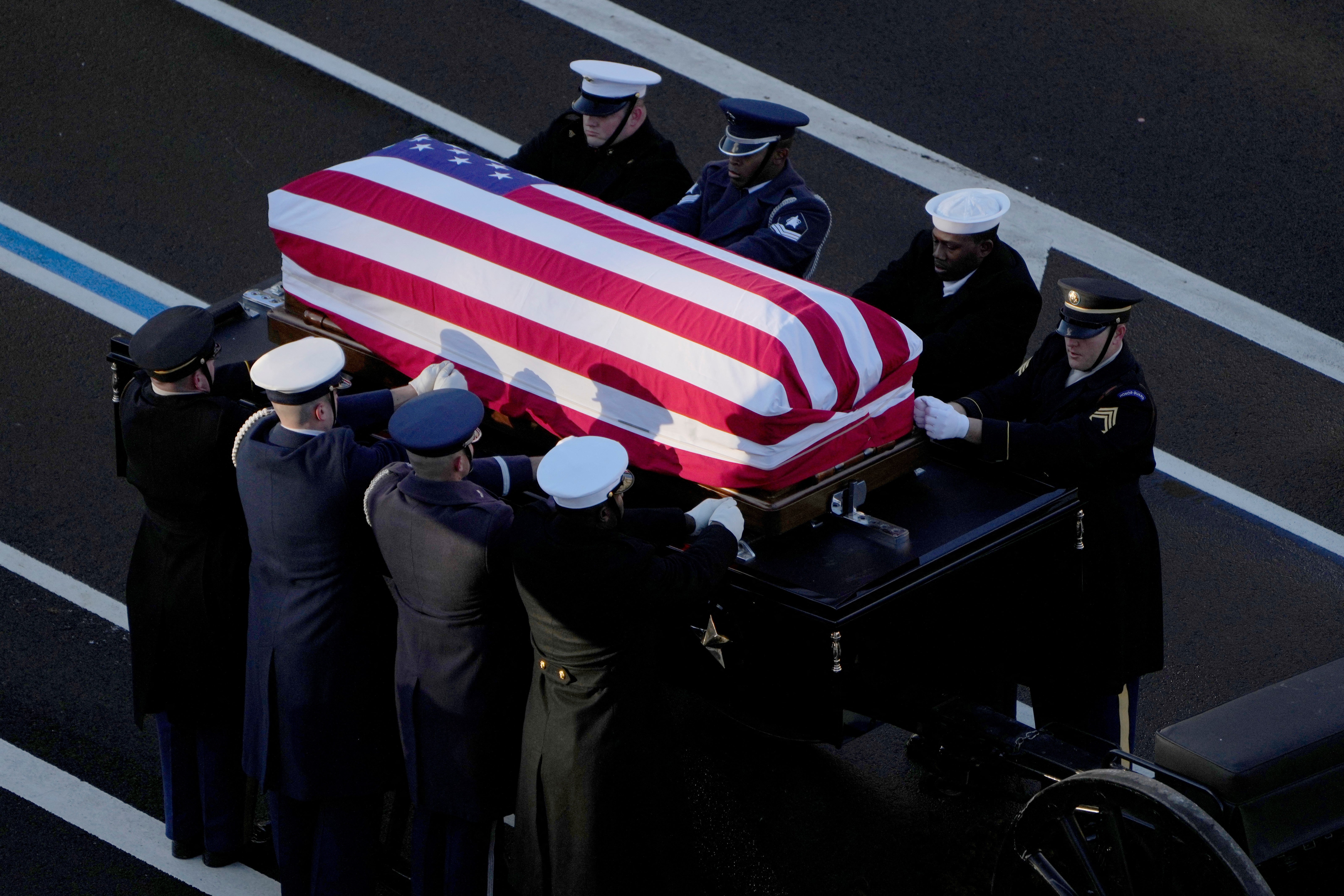 The flag-draped casket of former President Jimmy Carter is transferred to a horse-drawn caisson at the US Navy Memorial before traveling on to the Capitol in Washington, DC, on January 7, 2025, where Carter will lie in state