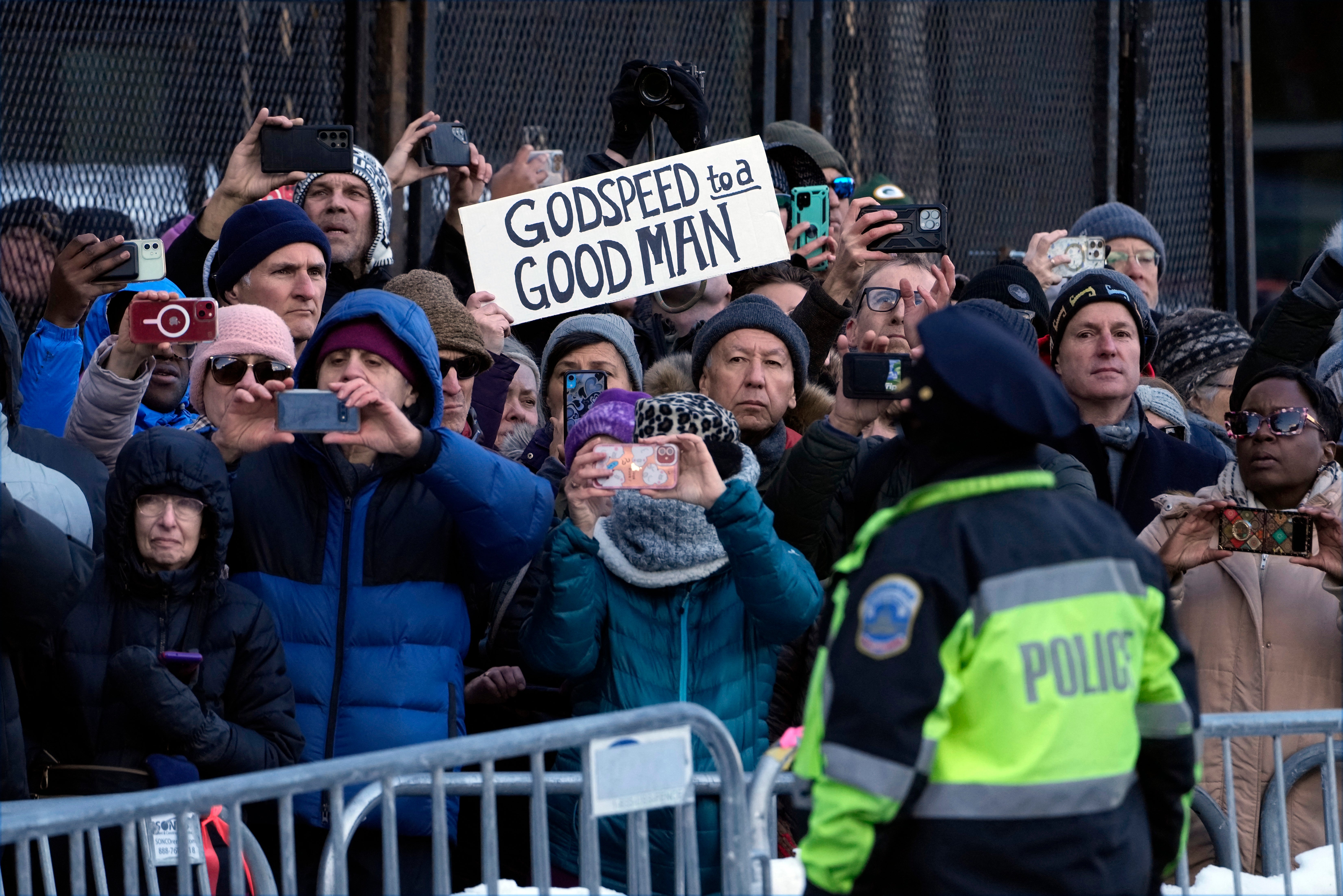 People watch as the casket of former President Jimmy Carter passes on a horse-drawn caisson on Pennsylvania Avenue in Washington, DC, on January 7, 2025, on its way to the US Capitol, where he will lie in state