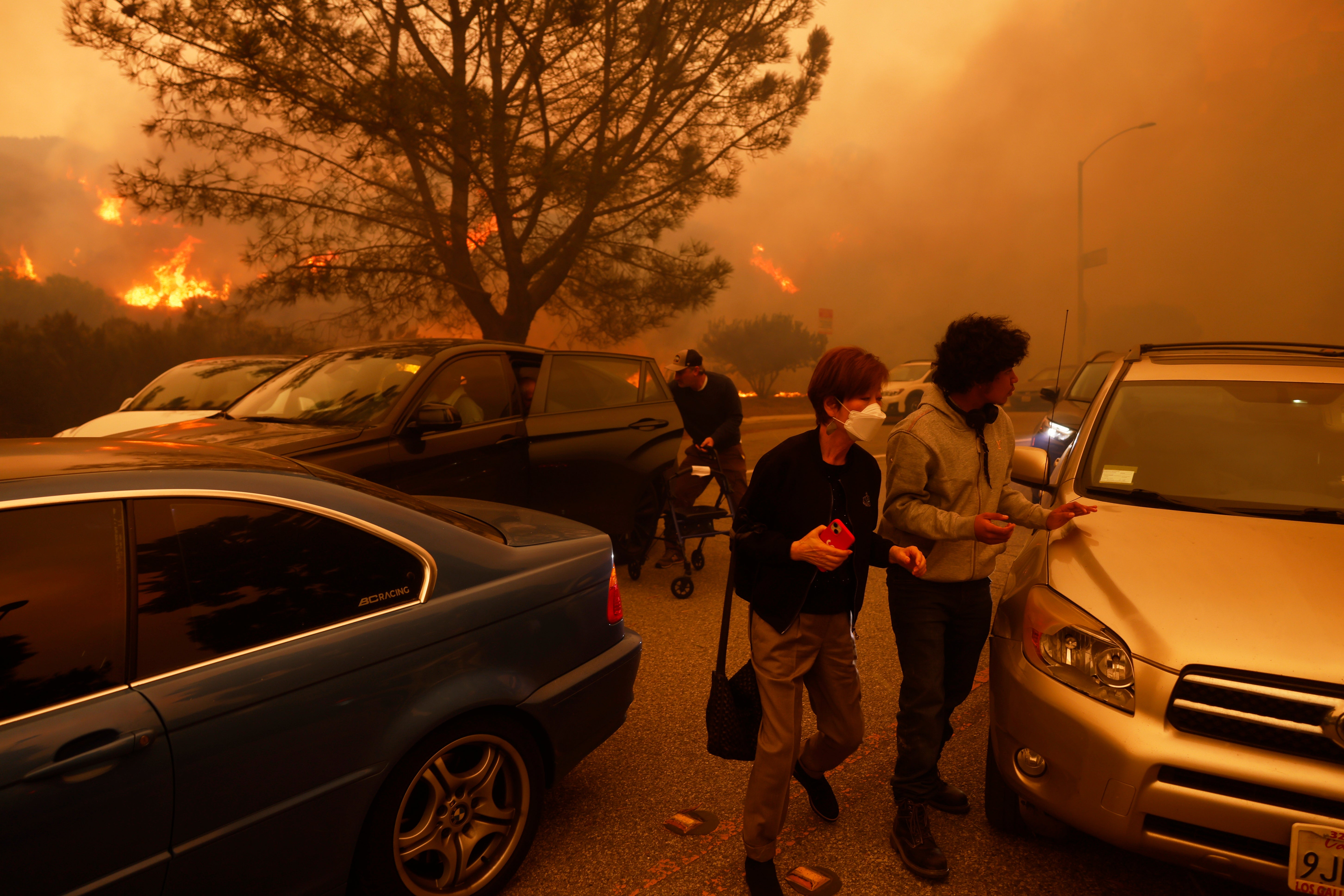 People flee from the advancing Palisades Fire in Pacific Palisades, California, on Tuesday. More than 27,000 people reside in the community