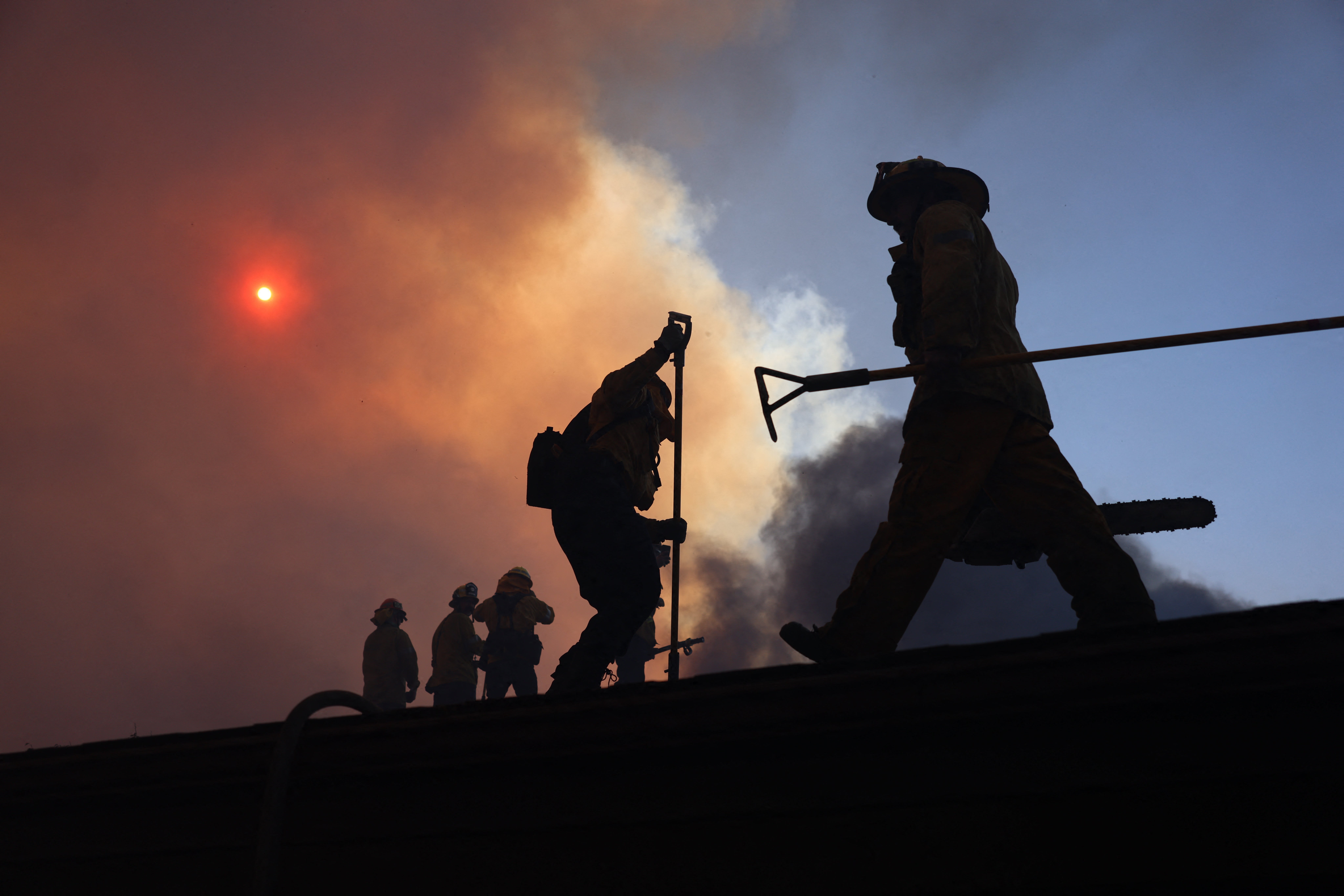 Firefighters work as a brush fire burns in Pacific Palisades, California, on Monday. Firefighters had been pre-positioned in vulnerable areas on Tuesday