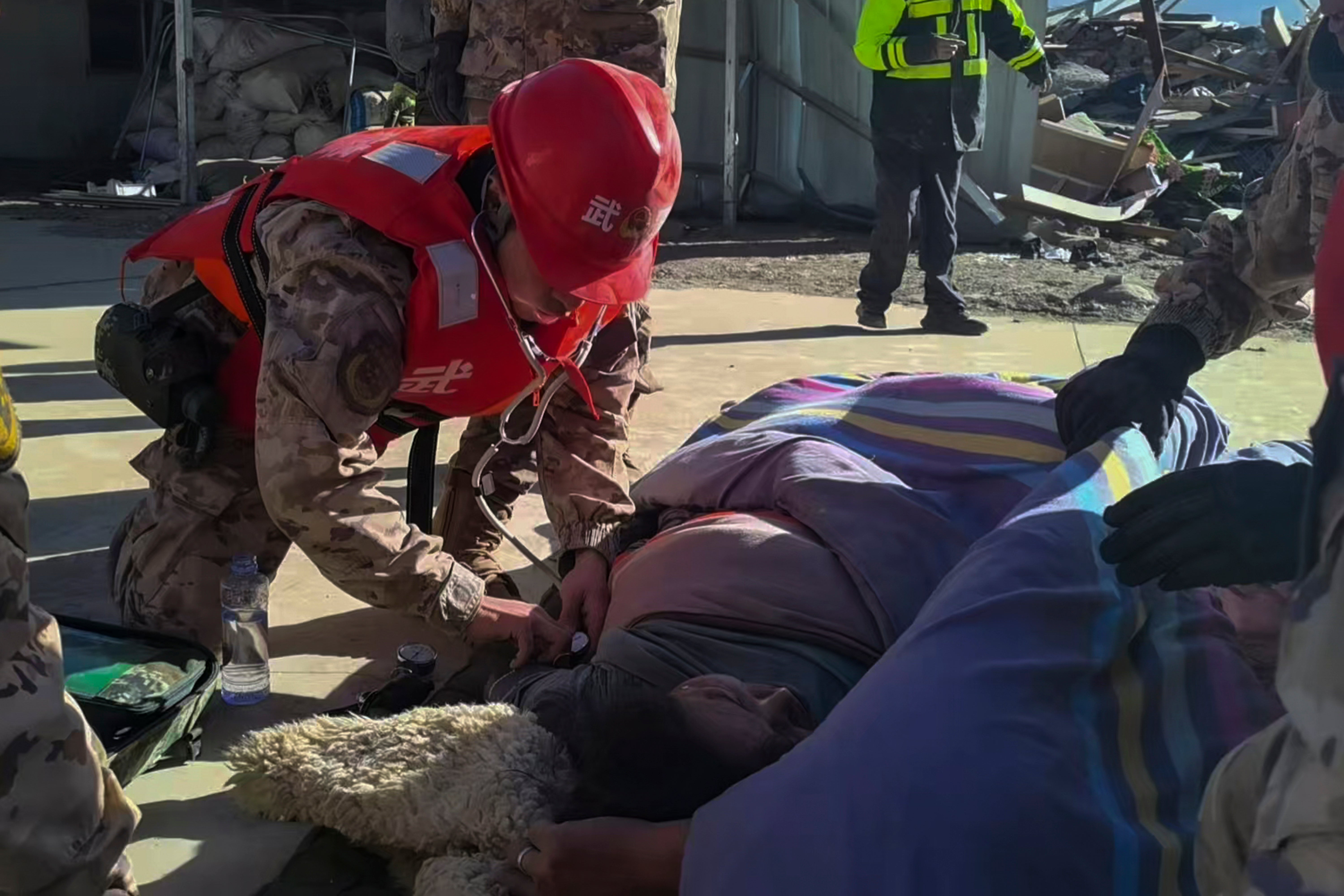 Rescue workers check on an injured resident in the aftermath of an earthquake in Changsuo Township of Dingri in Xigaze, southwestern China's Tibet Autonomous Region, on Tuesday