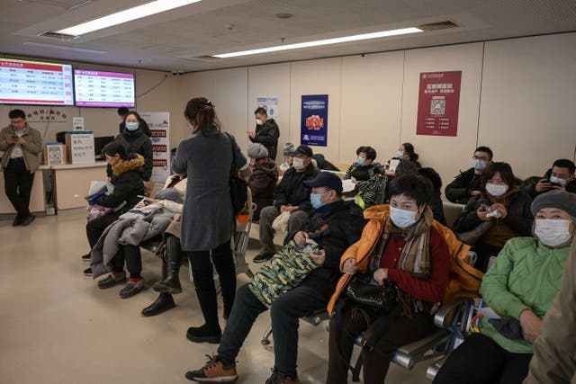 <p>People wearing masks wait at an outpatient area of the respiratory department of a hospital in Beijing </p>