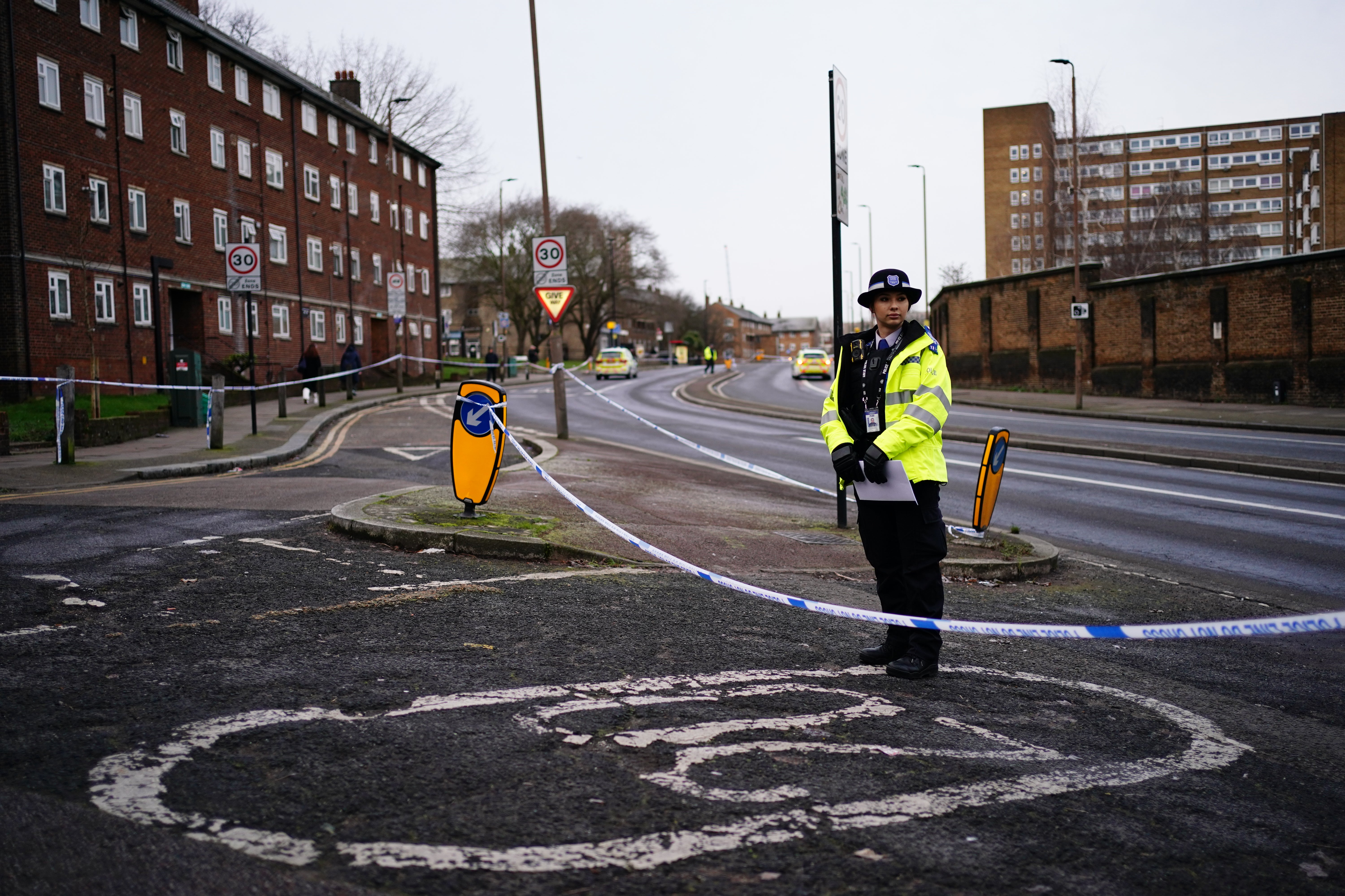 A police officer on Woolwich Church Road which is cordoned off as part of the investigation