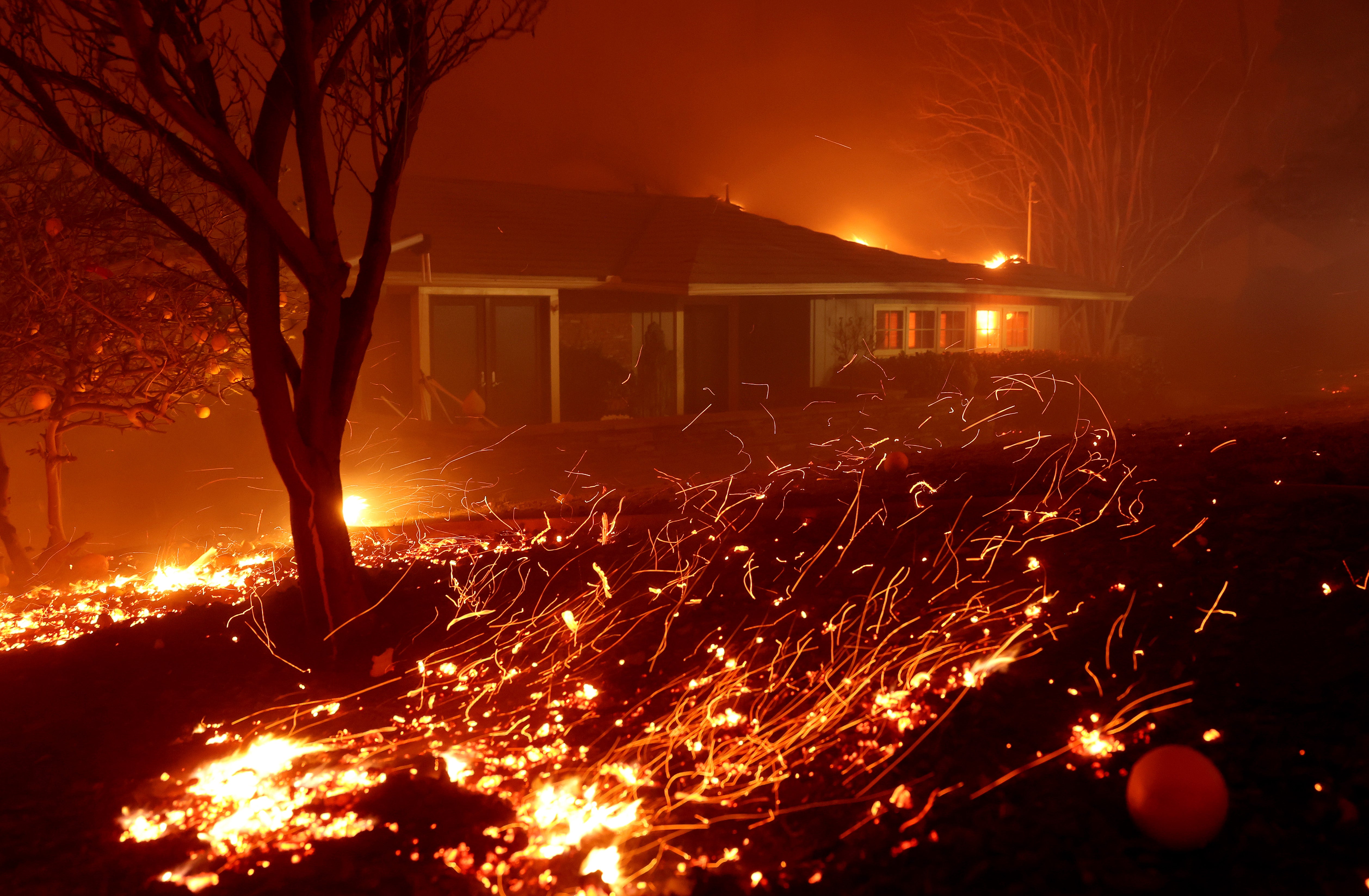 Wind pushes embers into a home as the Eaton Fire moves through the area on January 8, 2025 in Altadena, California