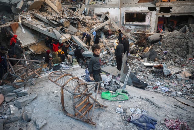 <p>People search the rubble of a building destroyed in an Israeli airstrike on the Gaza Strip</p>