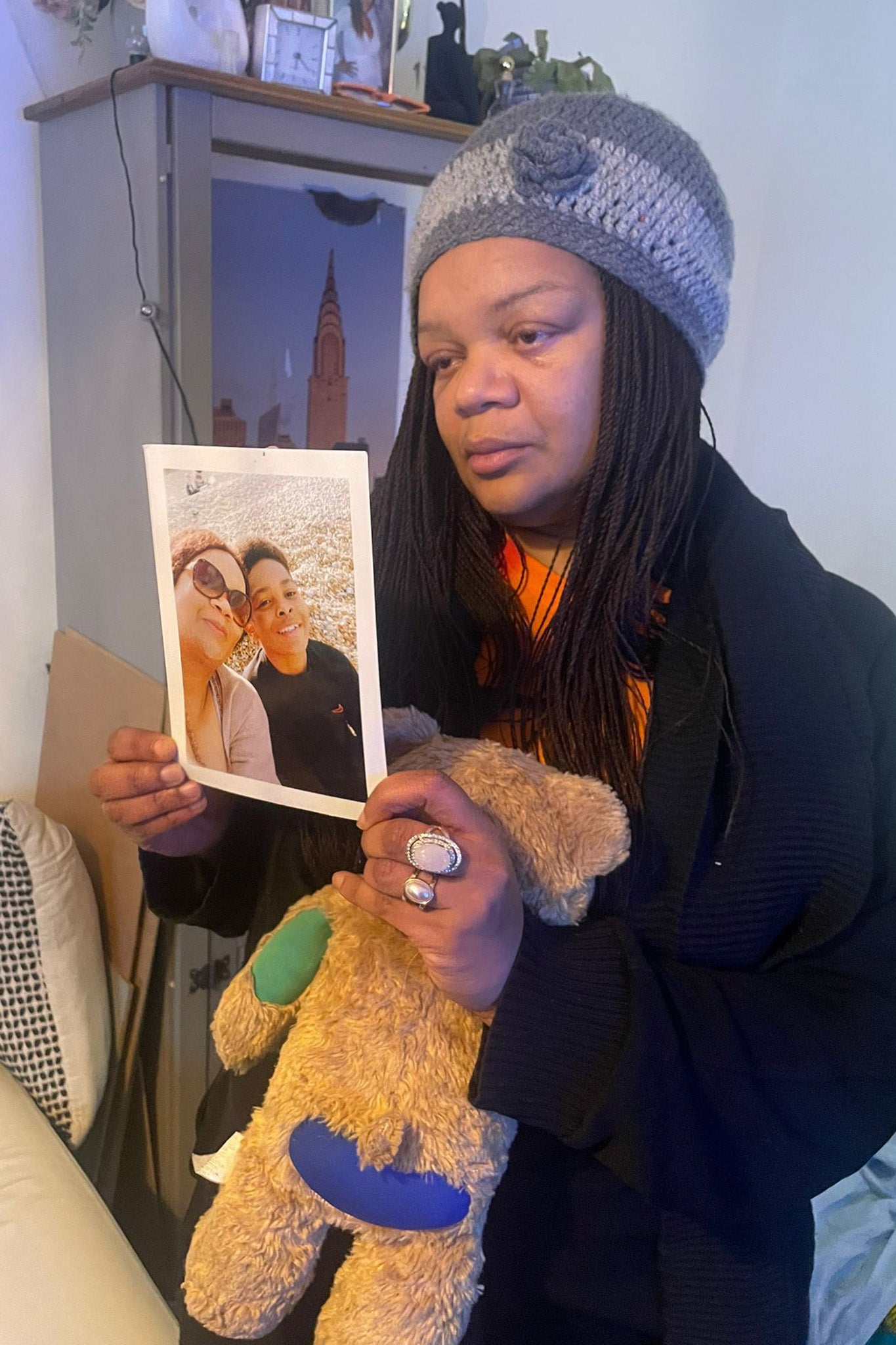 Ms Bokassa holding a photo of her son and a teddy bear