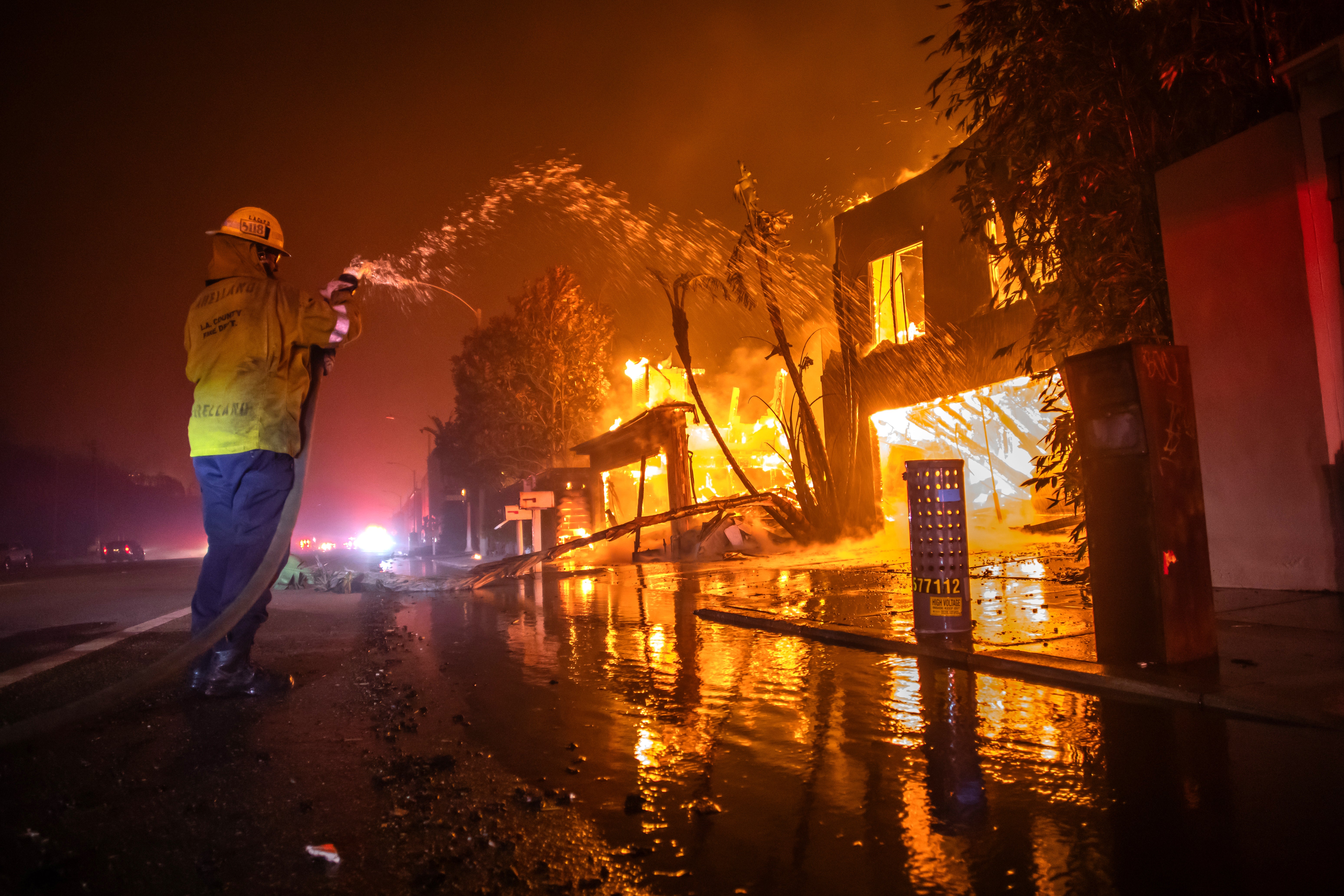 A firefighter battles the Palisades Fire while it burns homes in Los Angeles, California, on Wednesday.