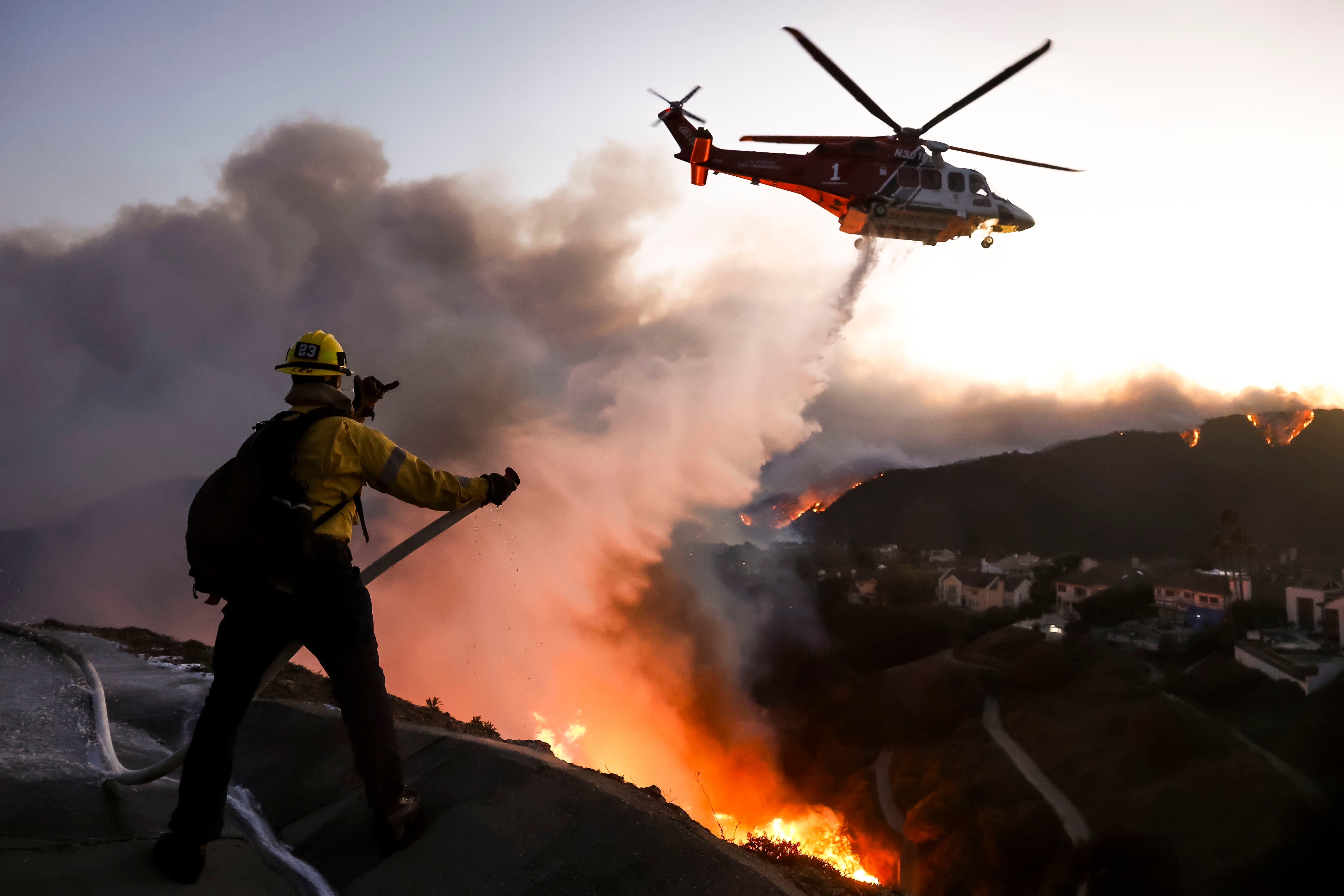 Los Angeles firefighters battle flames as more than 150,000 people evacuate