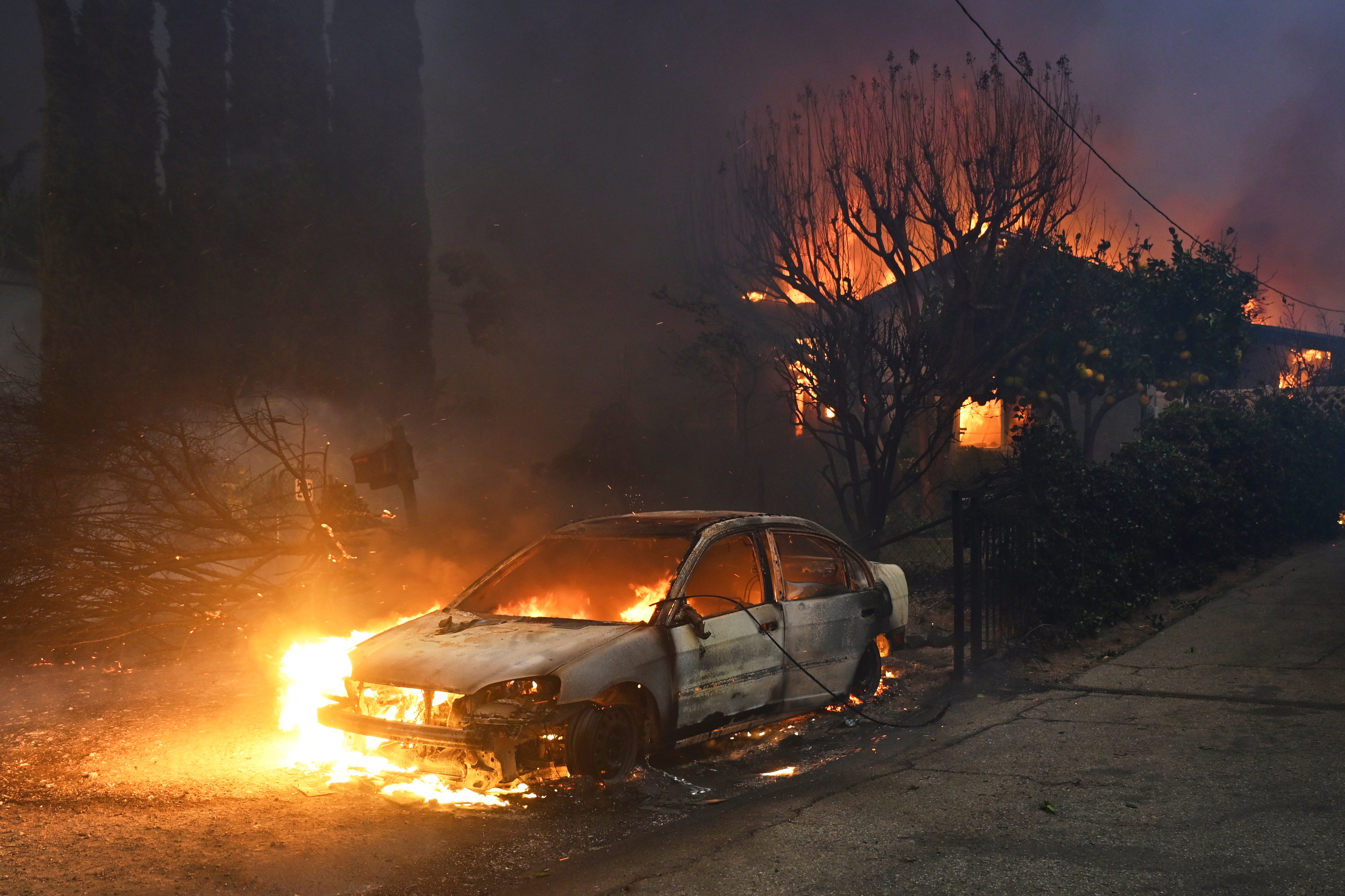 The Eaton Fire burns vehicles and structures in Altadena, California, on Wednesday. The Eaton fire continued to grow on Wednesday