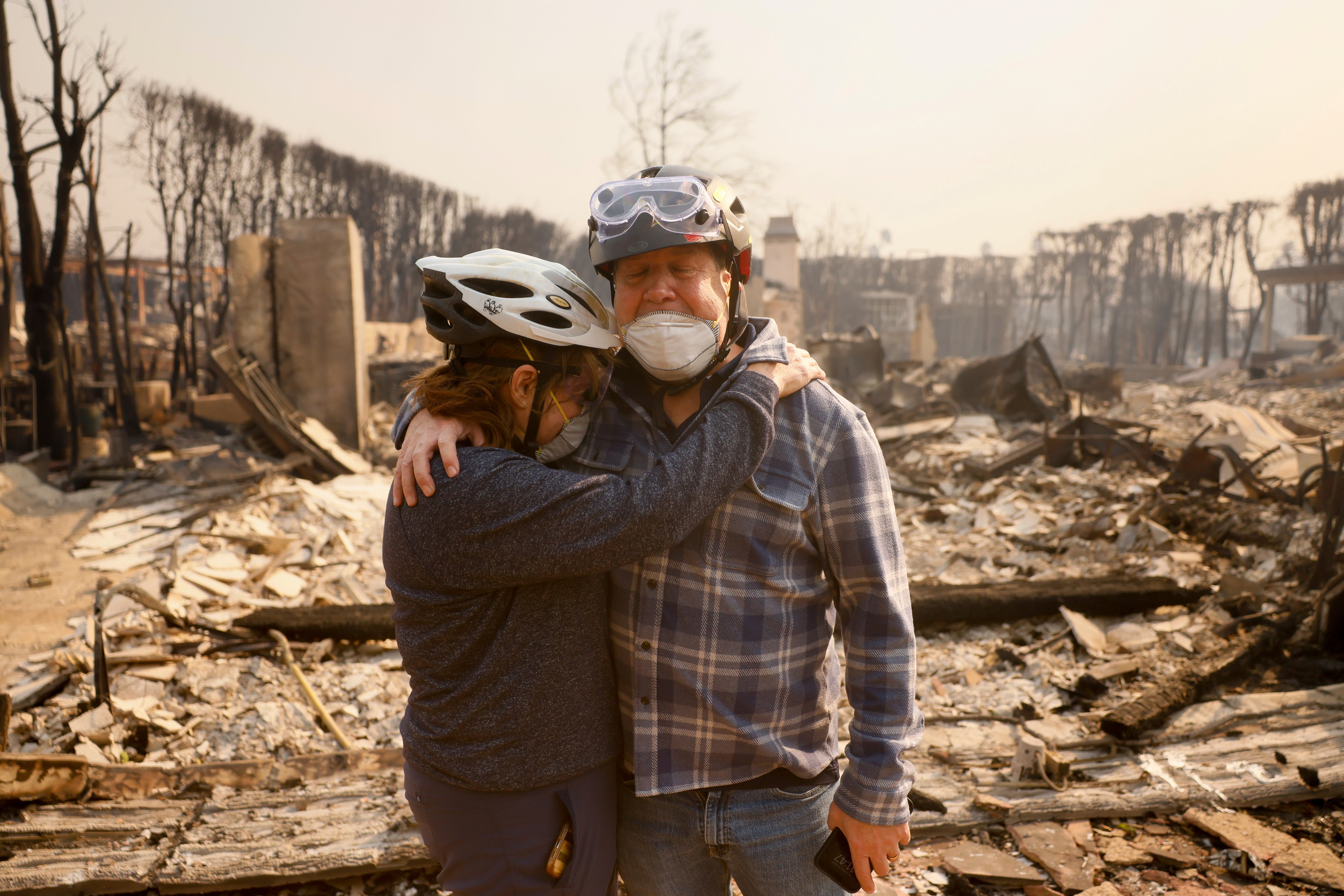 Claudio and Kathleen Boltiansky embrace in their fire-ravaged Los Angeles County neighborhood on Wednesday. About a thousand homes were destroyed by the Palisades Fire