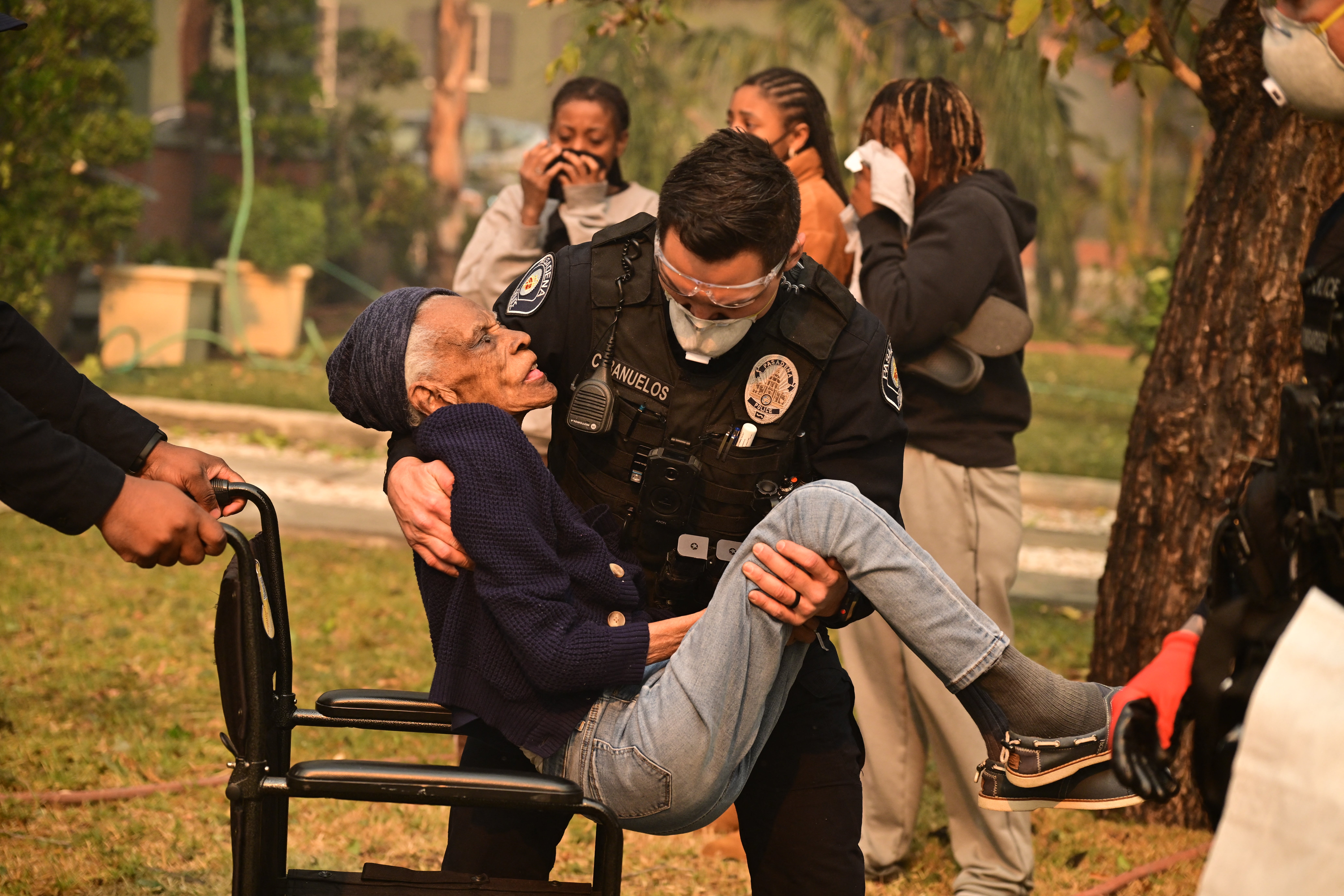 Police officers remove an elderly resident from her home during the Eaton Fire in Altadena, California, on Wednesday. She was identified by The New York Times as 101-year-old Laverna Sharpe