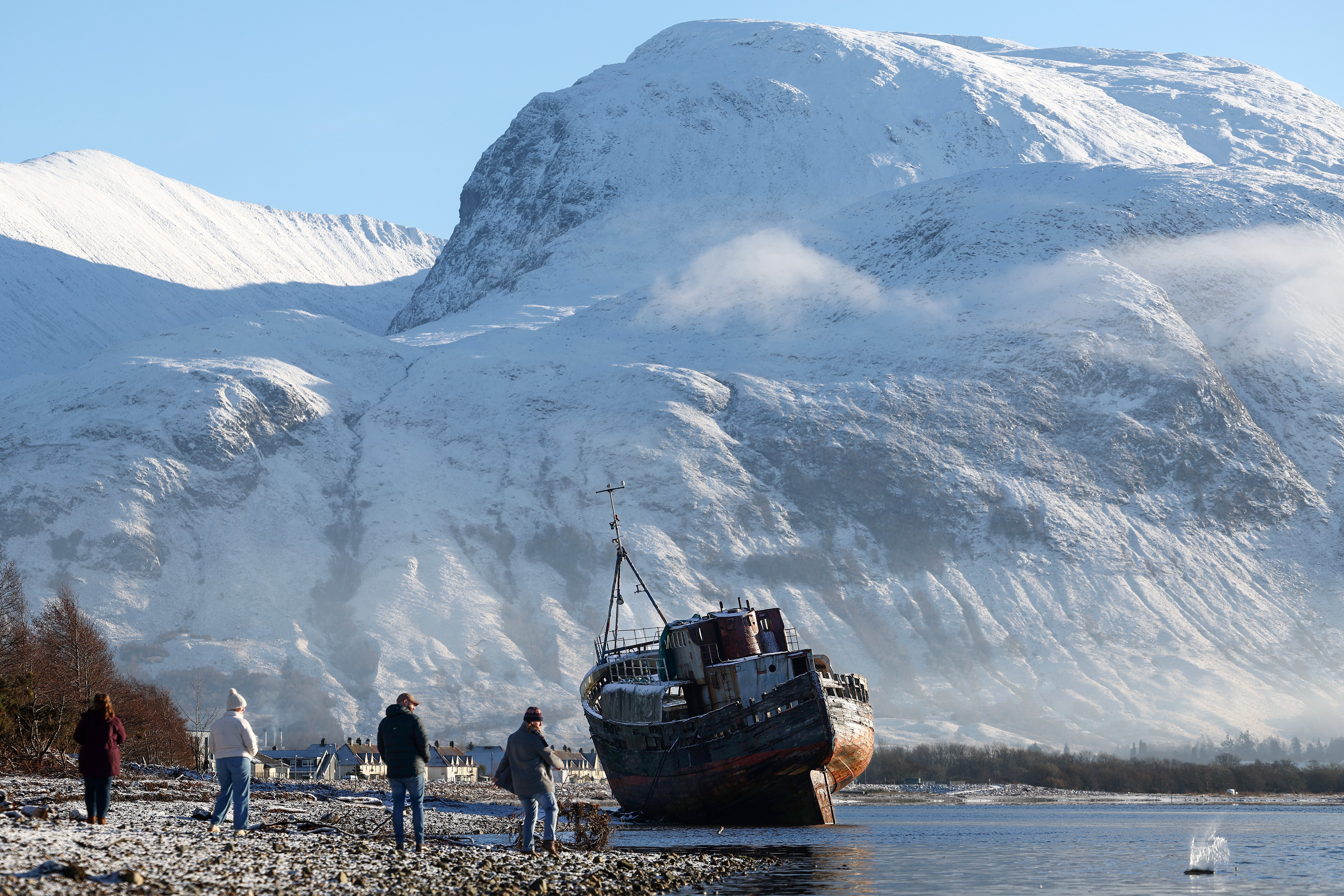 People view a former fishing boat on the shore of Loch Linnhe in front of Ben Nevis on 8 January 2025 in Corpach, United Kingdom