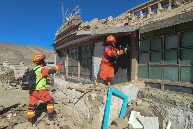 <p>Rescuers inspect a damaged house in Tibet</p>