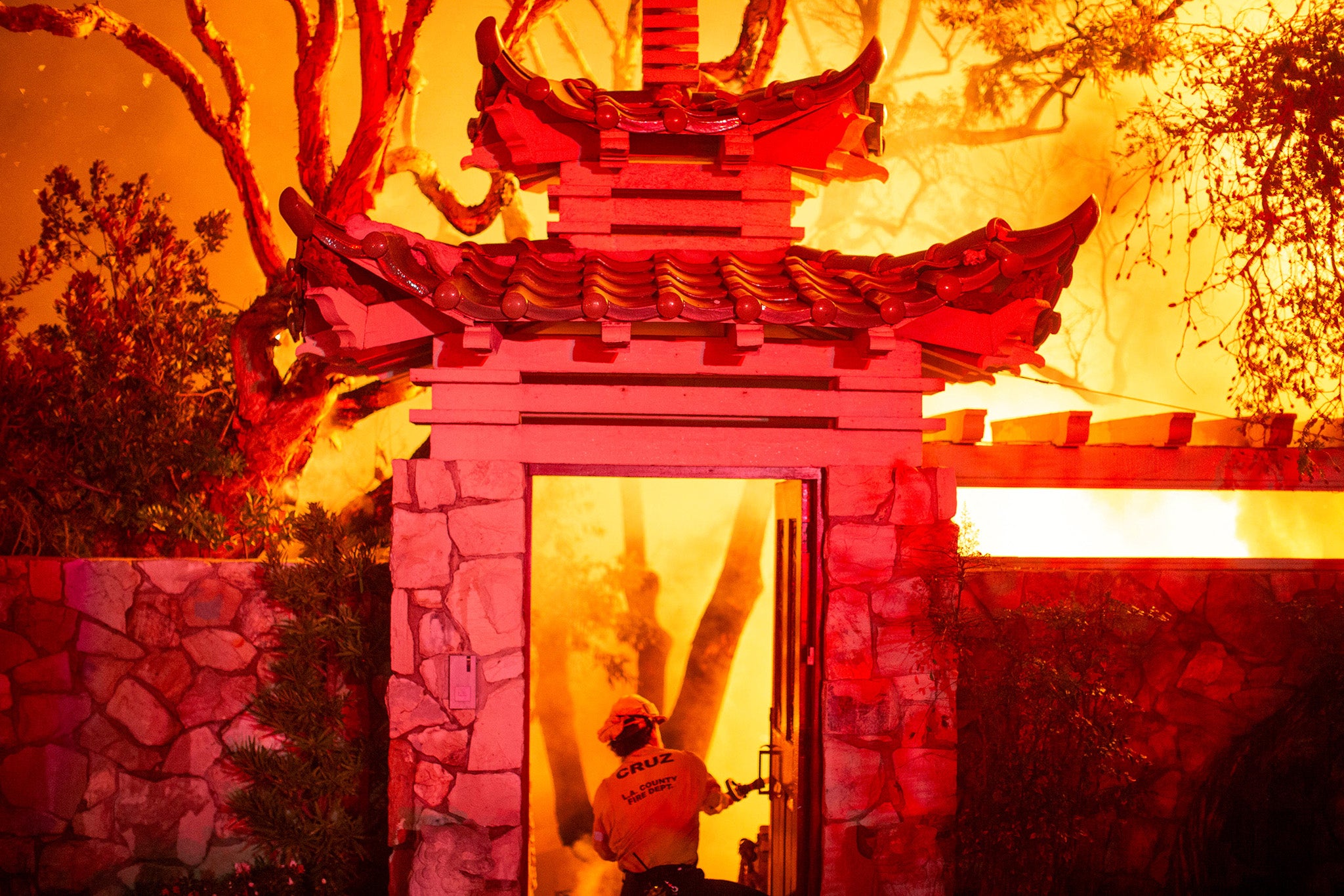 A firefighter battles the Palisades Fire as it burns during a windstorm on the west side of Los Angeles,