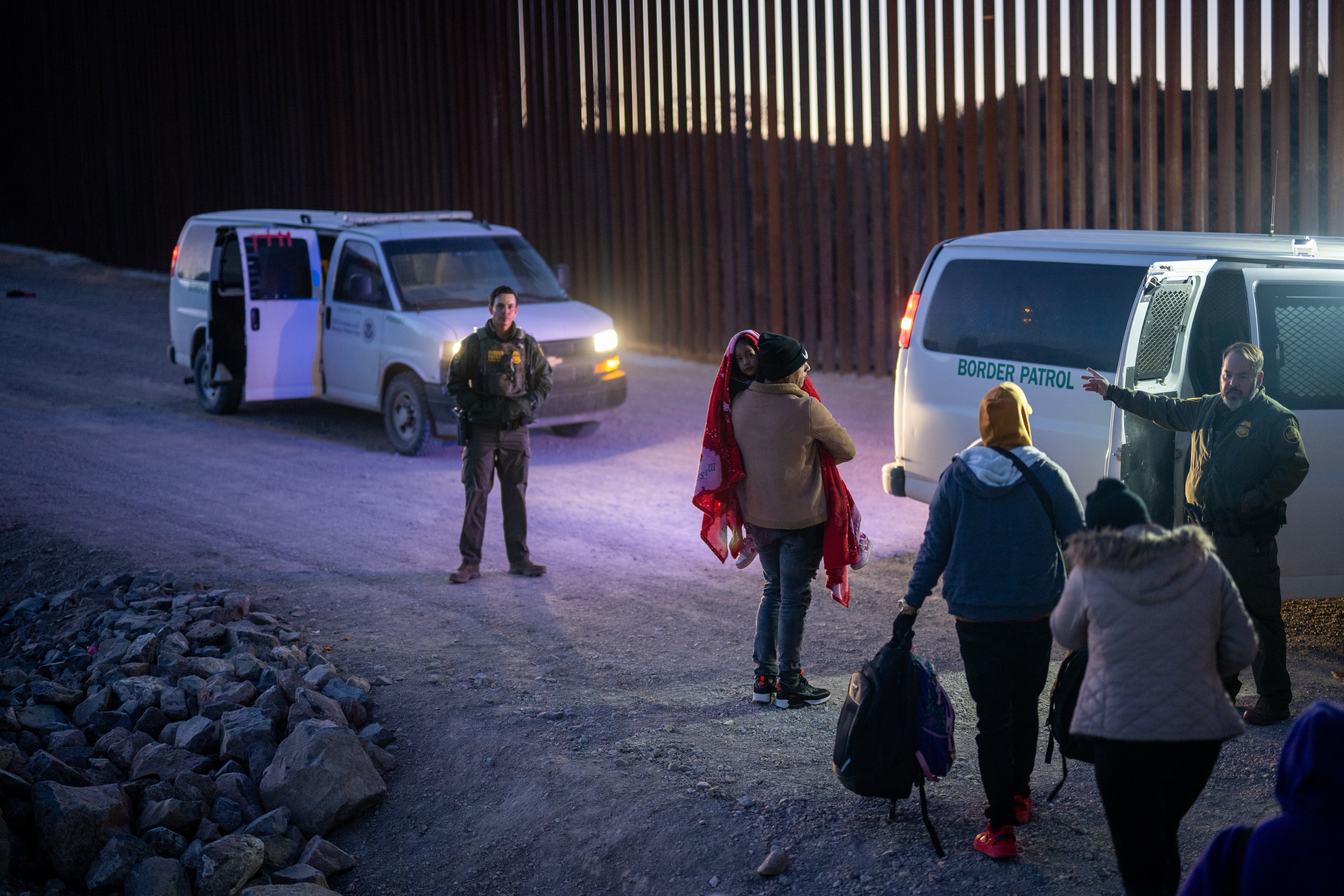 Immigrants turn themselves in to U.S. Customs and Border Patrol officers after crossing over a section of border wall January 5 in Arizona.