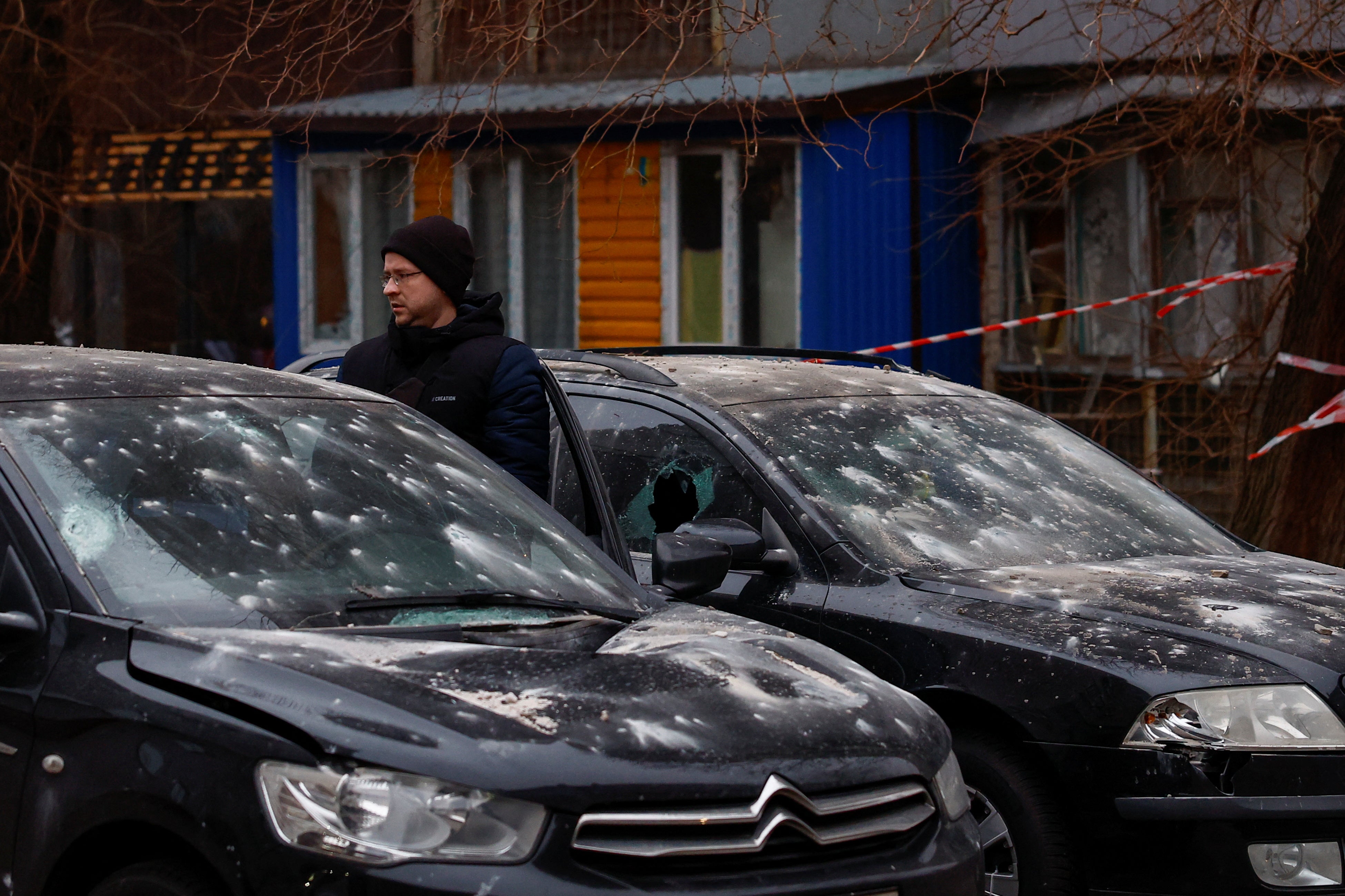 A resident inspects his car damaged after a Russian drone strike on Ukraine