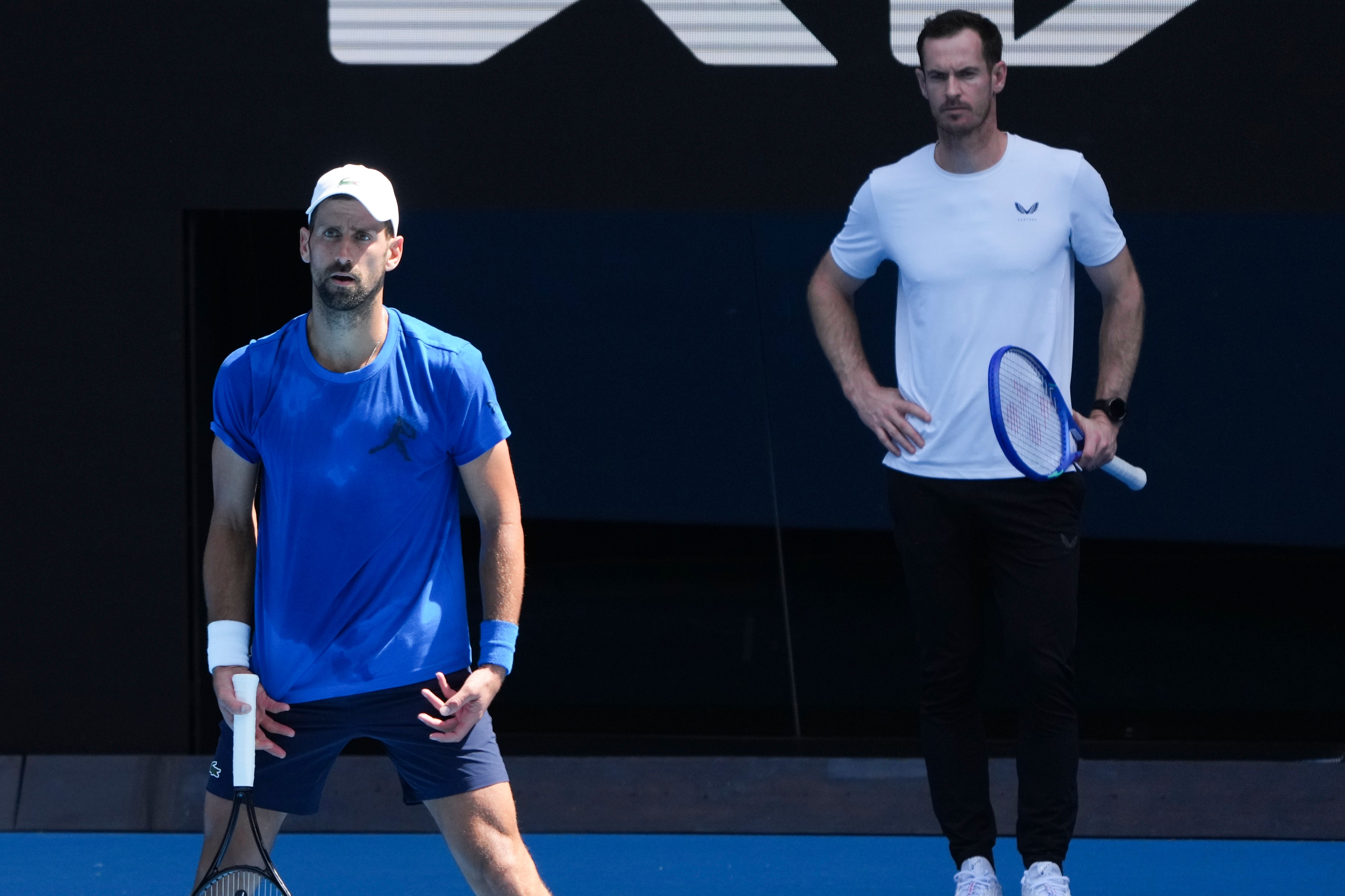 Andy Murray, right, watches Novak Djokovic practice (Mark Baker/AP)