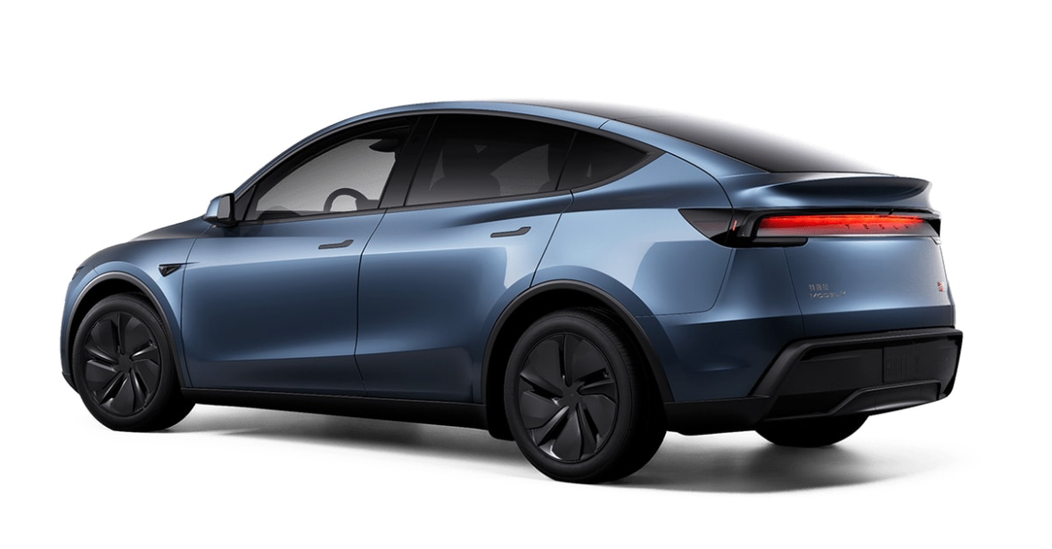 The rear of the new 2025 Tesla Model Y features a full-width light bar using reflective light, plus the Tesla name spelled out