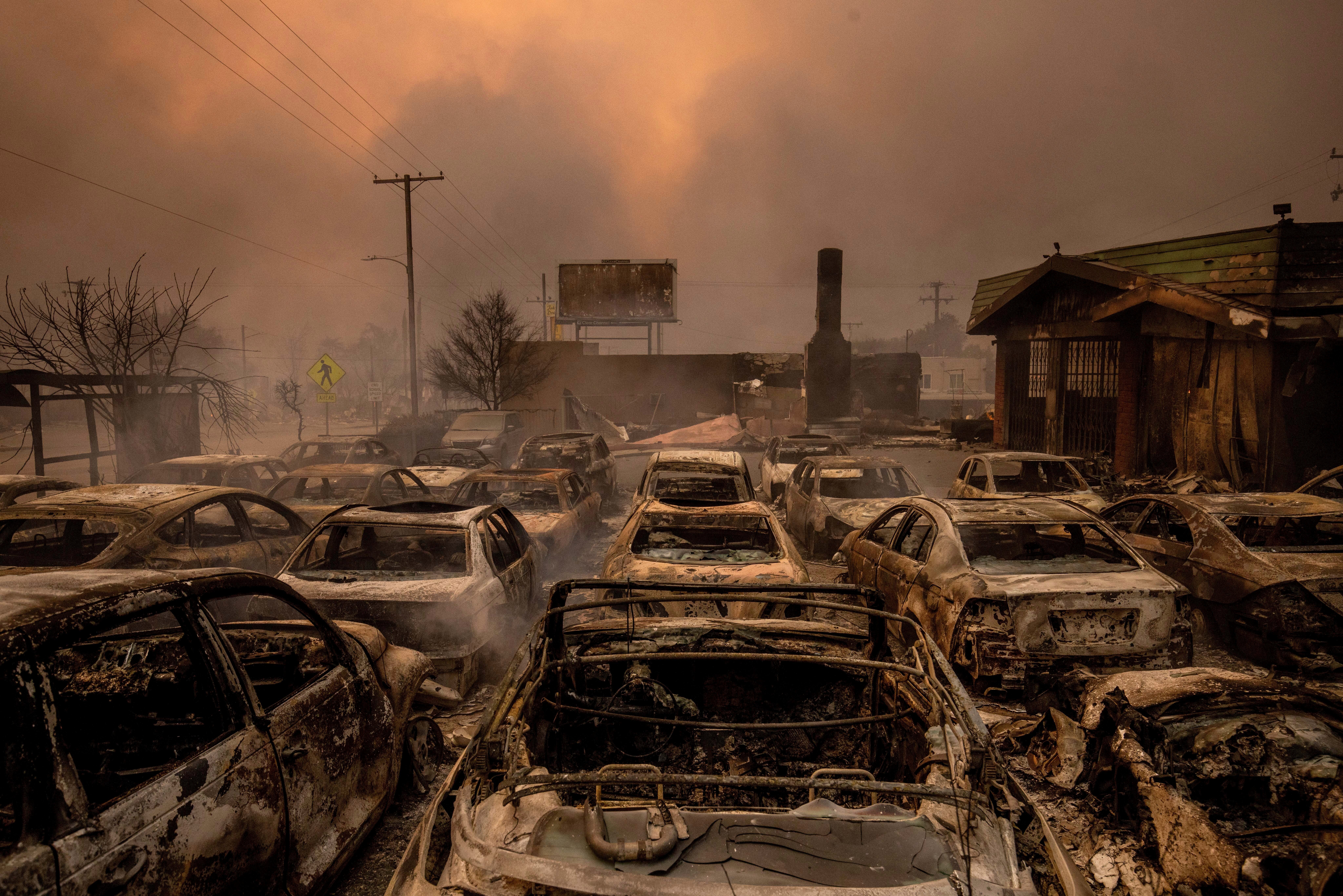 Fire-damaged vehicles are lined up at a dealership after the Eaton Fire on Wednesday in Altadena, California. Windy weather was expected to continue on Friday, fanning the flames