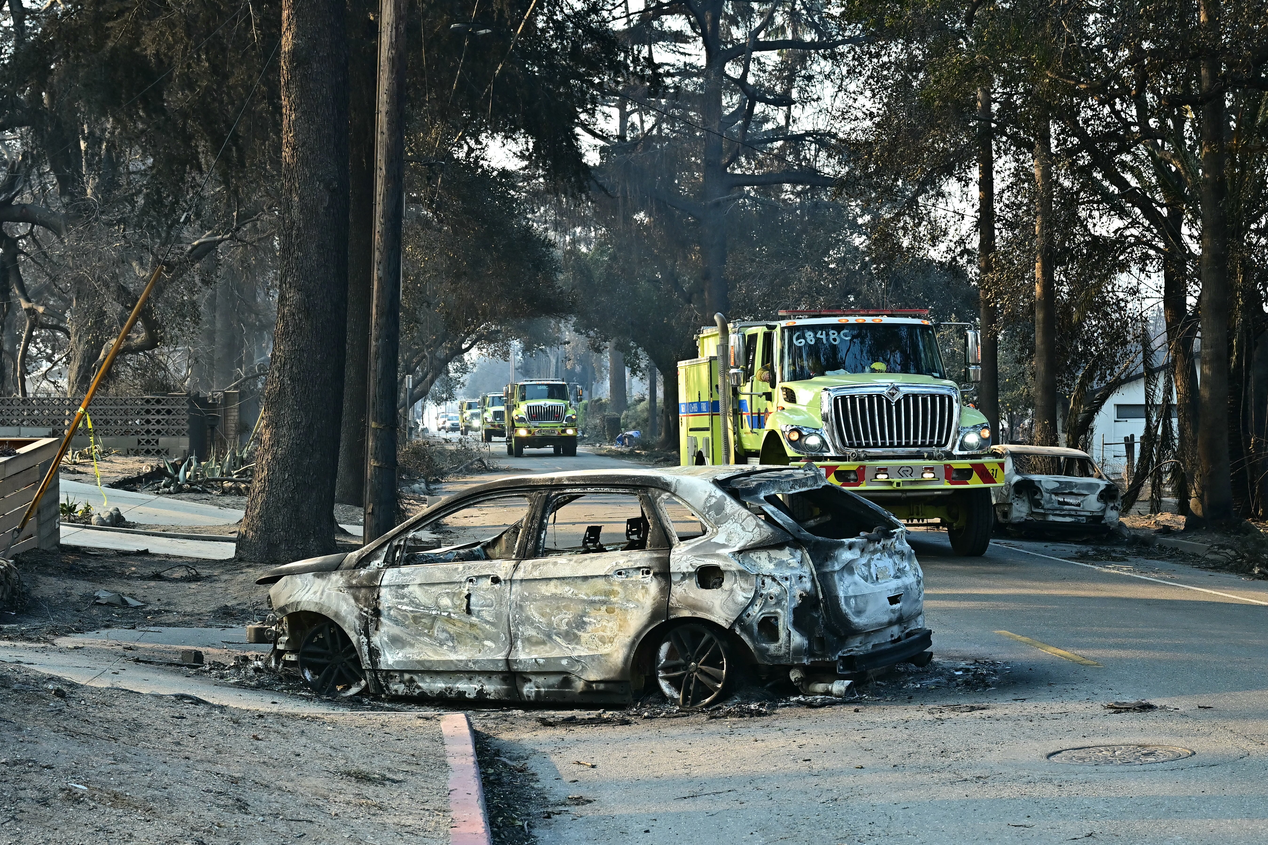 Firefighters travel through destruction left by the Eaton Fire in Altadena, California, on Friday. Thousands have been deployed to assist with the fires