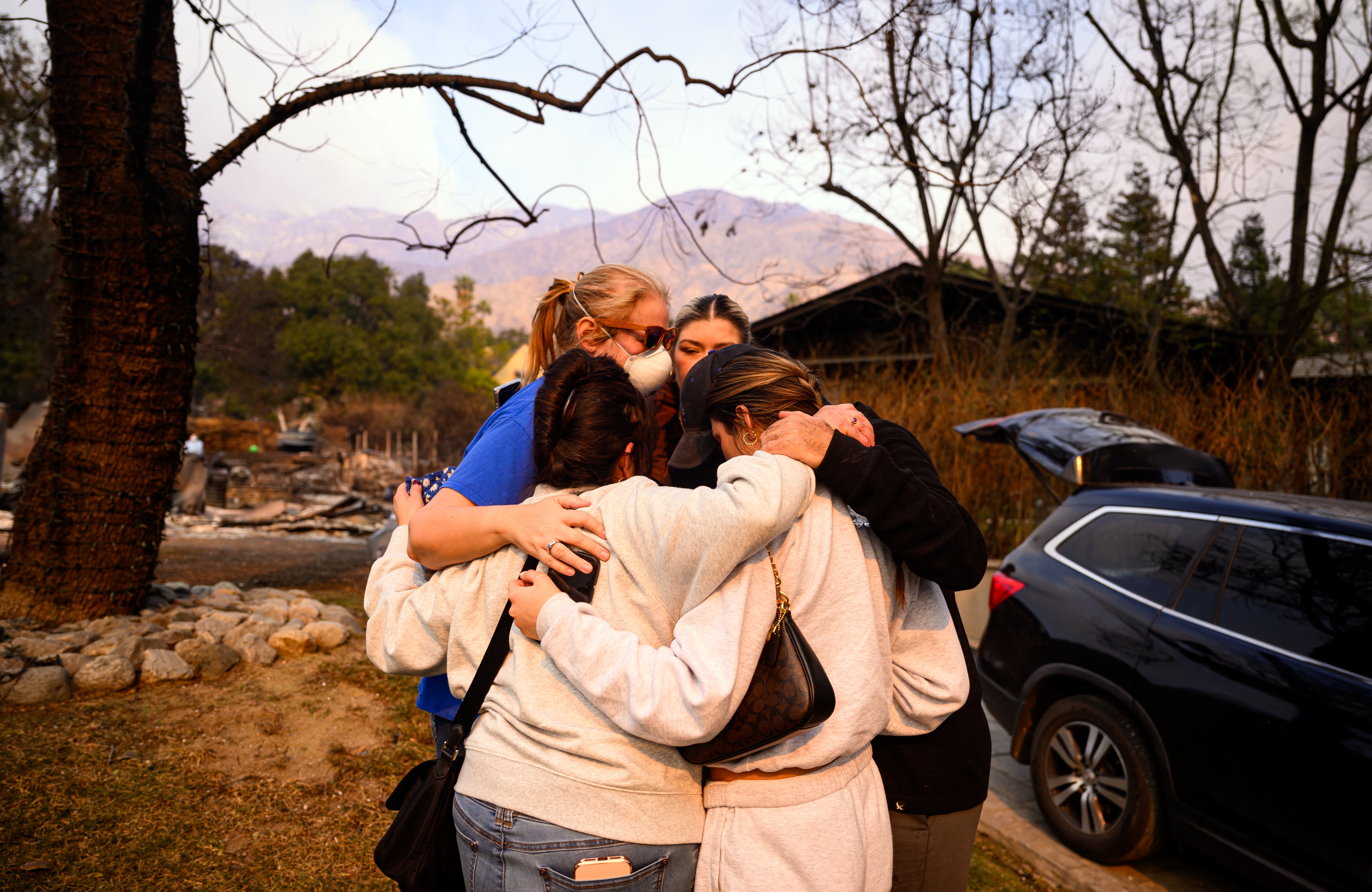 A family cries as they discover their Altadena home was scorched by the Eaton Fire on Thursday. Several residents like them are now returning to find their homes were destroyed by the flames