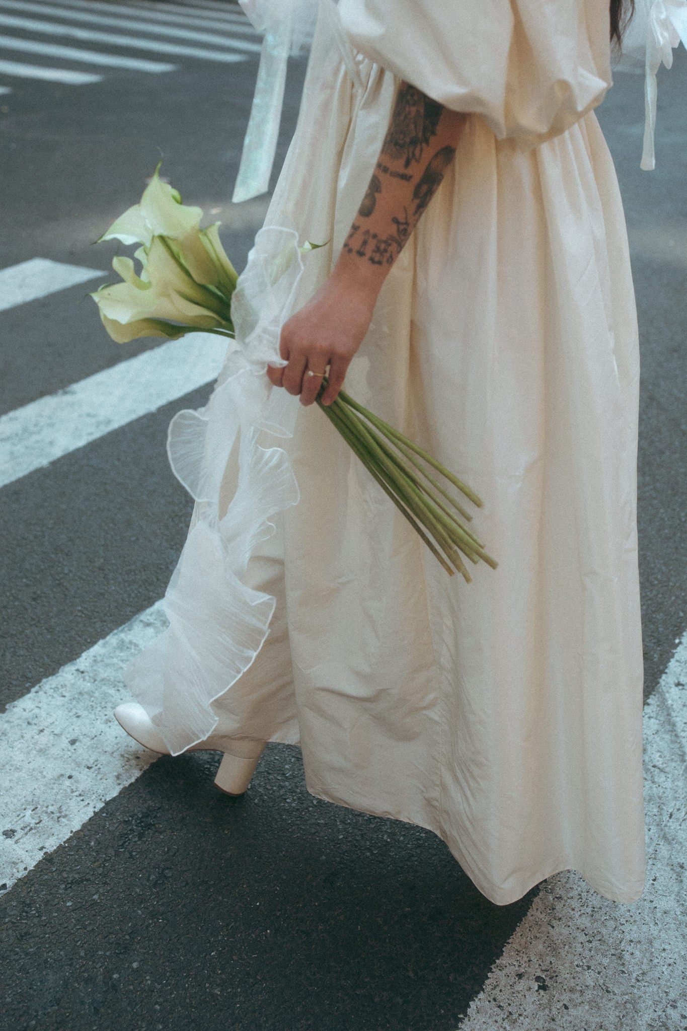 Photo of a bride holding calla lilies, captured by Sylvie Rosokoff