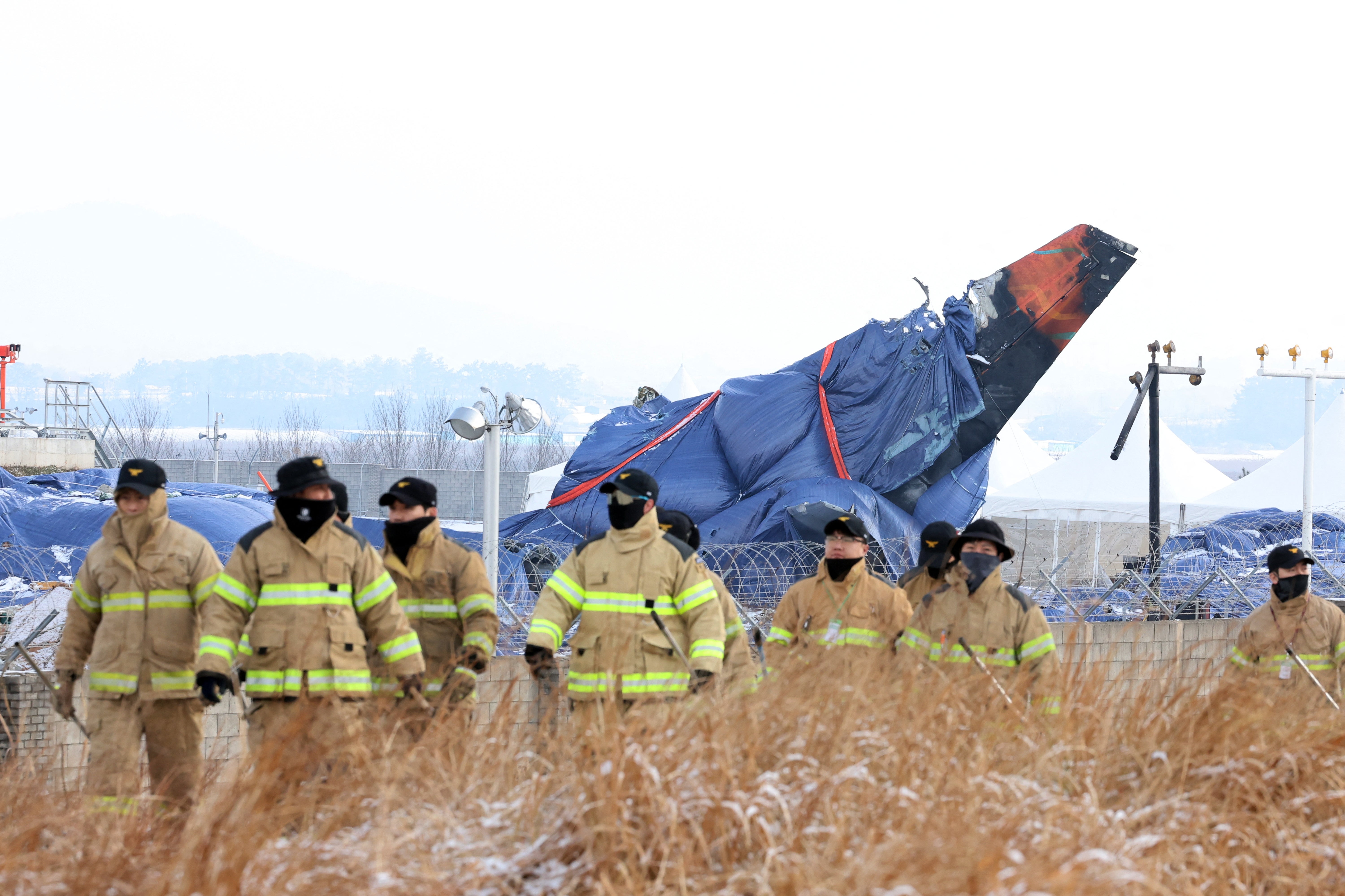 Firefighters take part in a search operation near the site where a Jeju Air Boeing 737-800 aircraft crashed and burst into flames