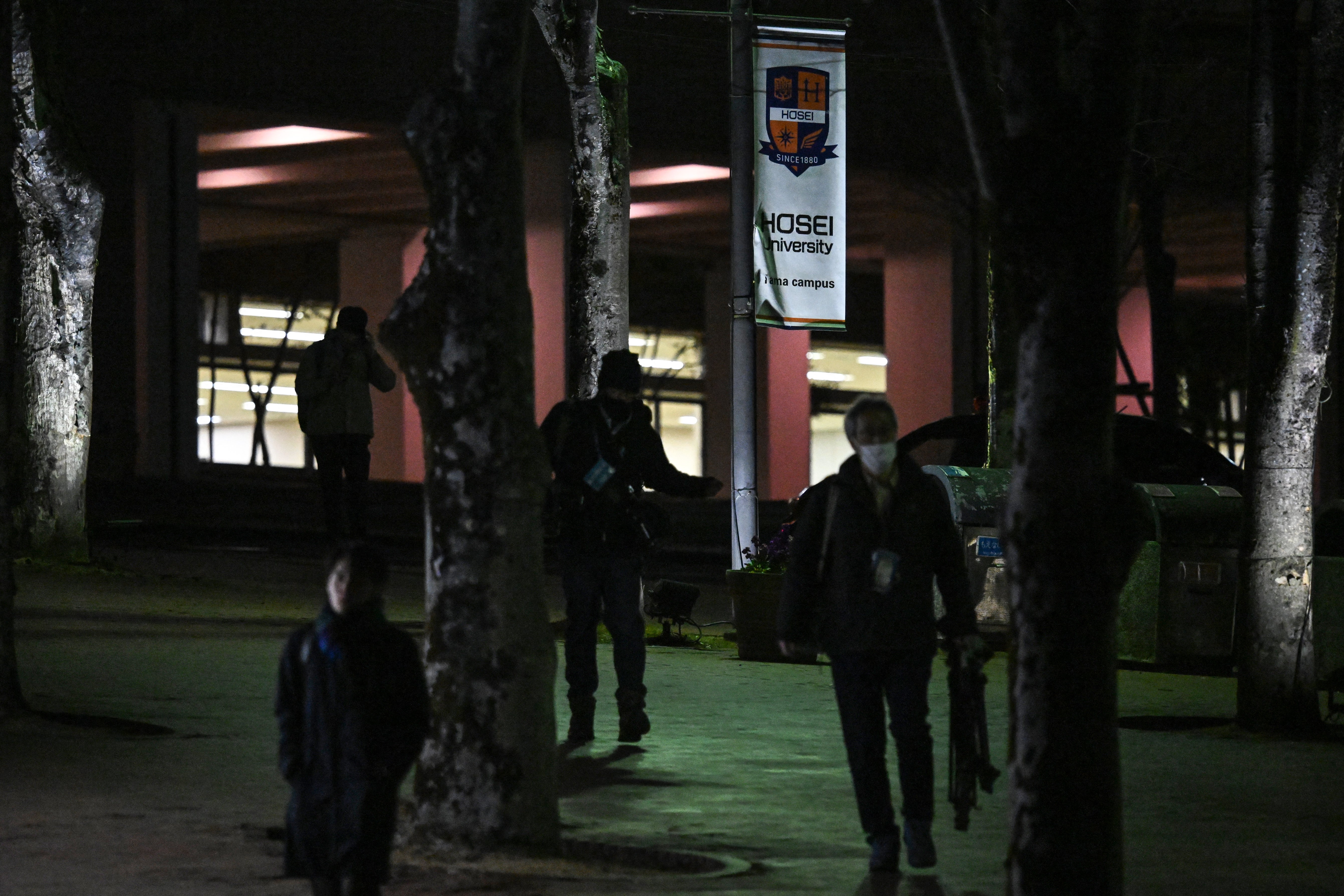 People walk past a banner (C-top) for Hosei University near the entrance to the university’s Tama campus after a woman brandished a hammer inside a classroom, in Machida in the western suburbs of Tokyo on January 10, 2025