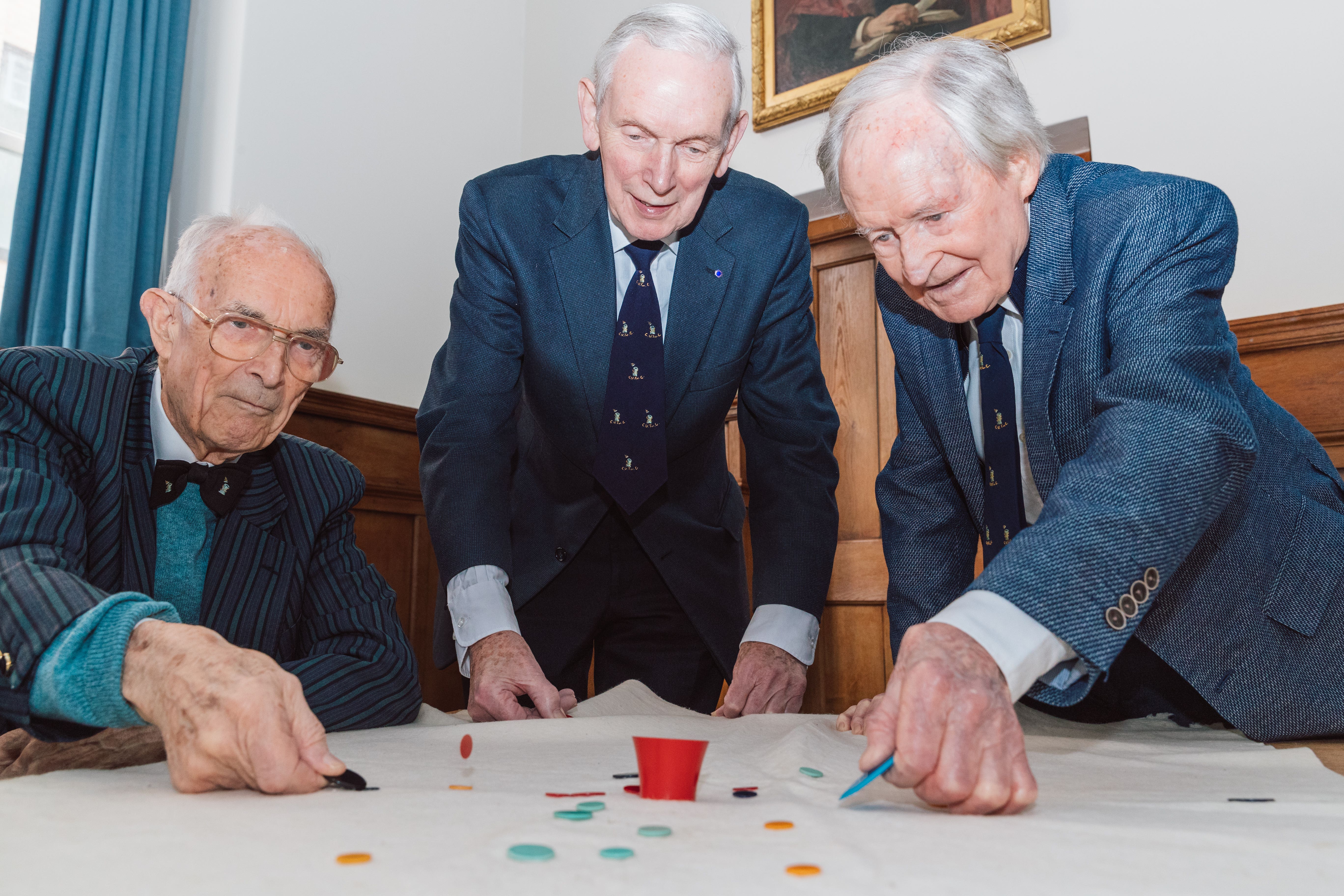 Bill Steen, Peter Downes and Lawford Howells celebrate the 70th anniversary of competitive tiddlywinks. (Cambridge University/PA)