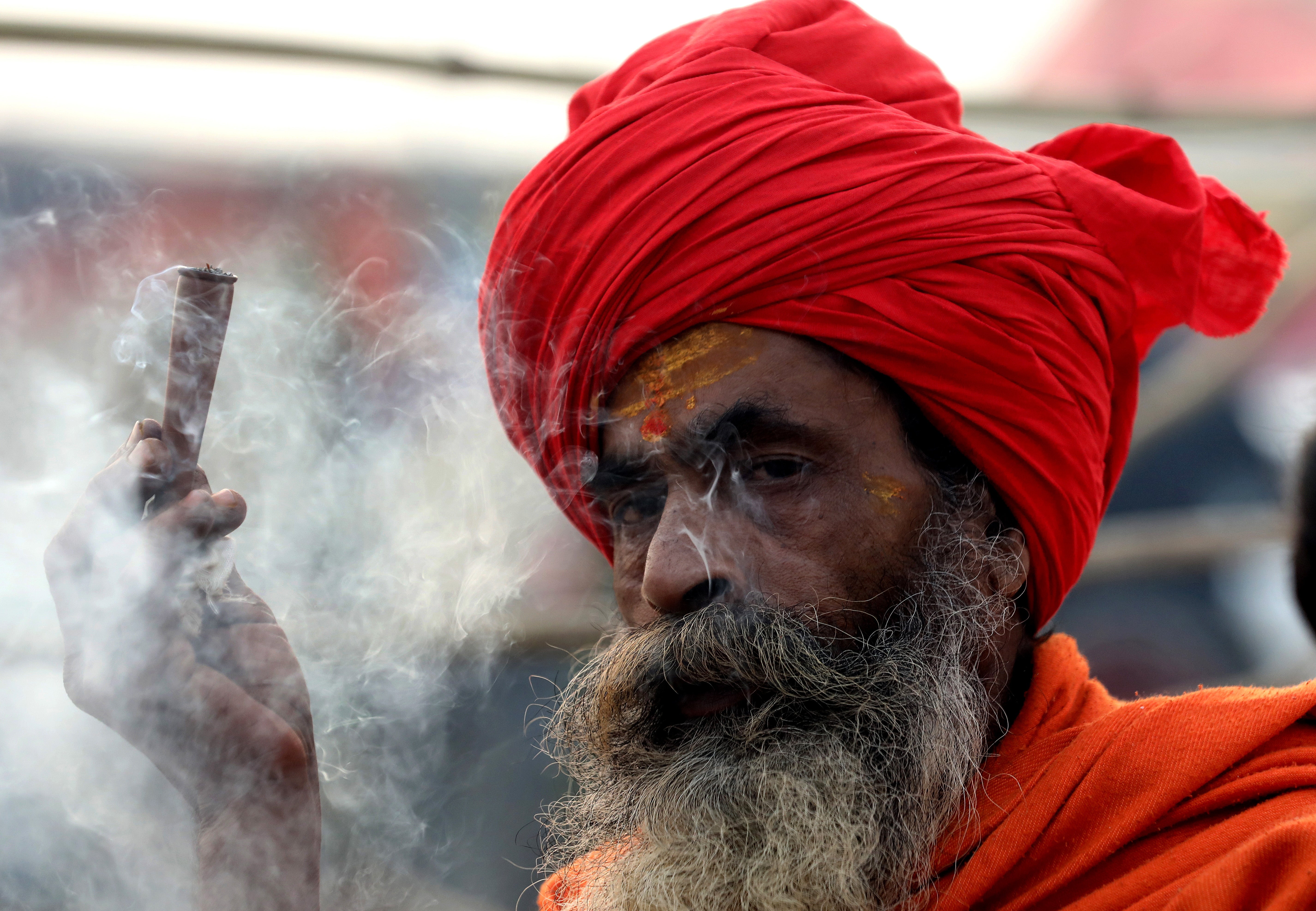 A Hindu holy man from Juna Akhara smokes ahead of the Royal Bath near the Sangam