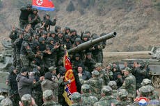 soldiers are gathered around a tank with a flag and a flag