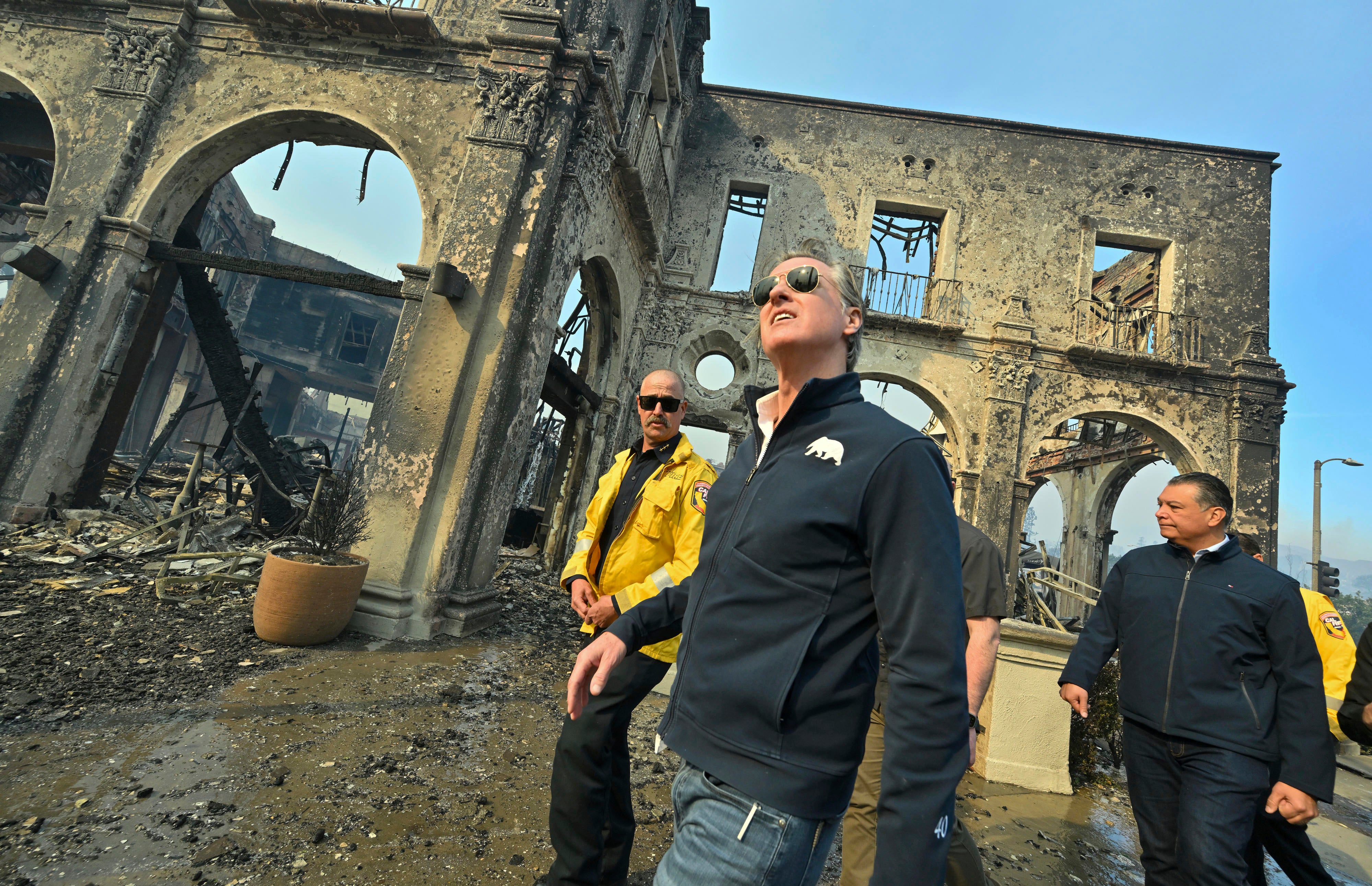 California Governor Gavin Newsom, center, surveys damage from the Palisades Fire earlier this month in Pacific Palisades, California. Newsom has sought to correct misinformation about wildfire response and the state’s water resources