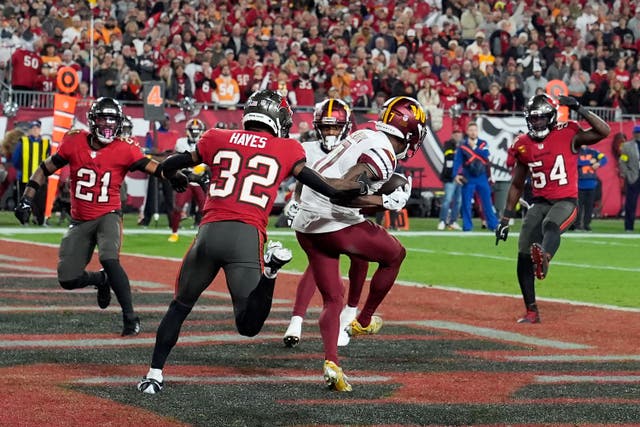 Washington Commanders wide receiver Terry McLaurin, middle, catches a touchdown pass in front of Tampa Bay Buccaneers safety Josh Hayes (Chris O’Meara/AP)