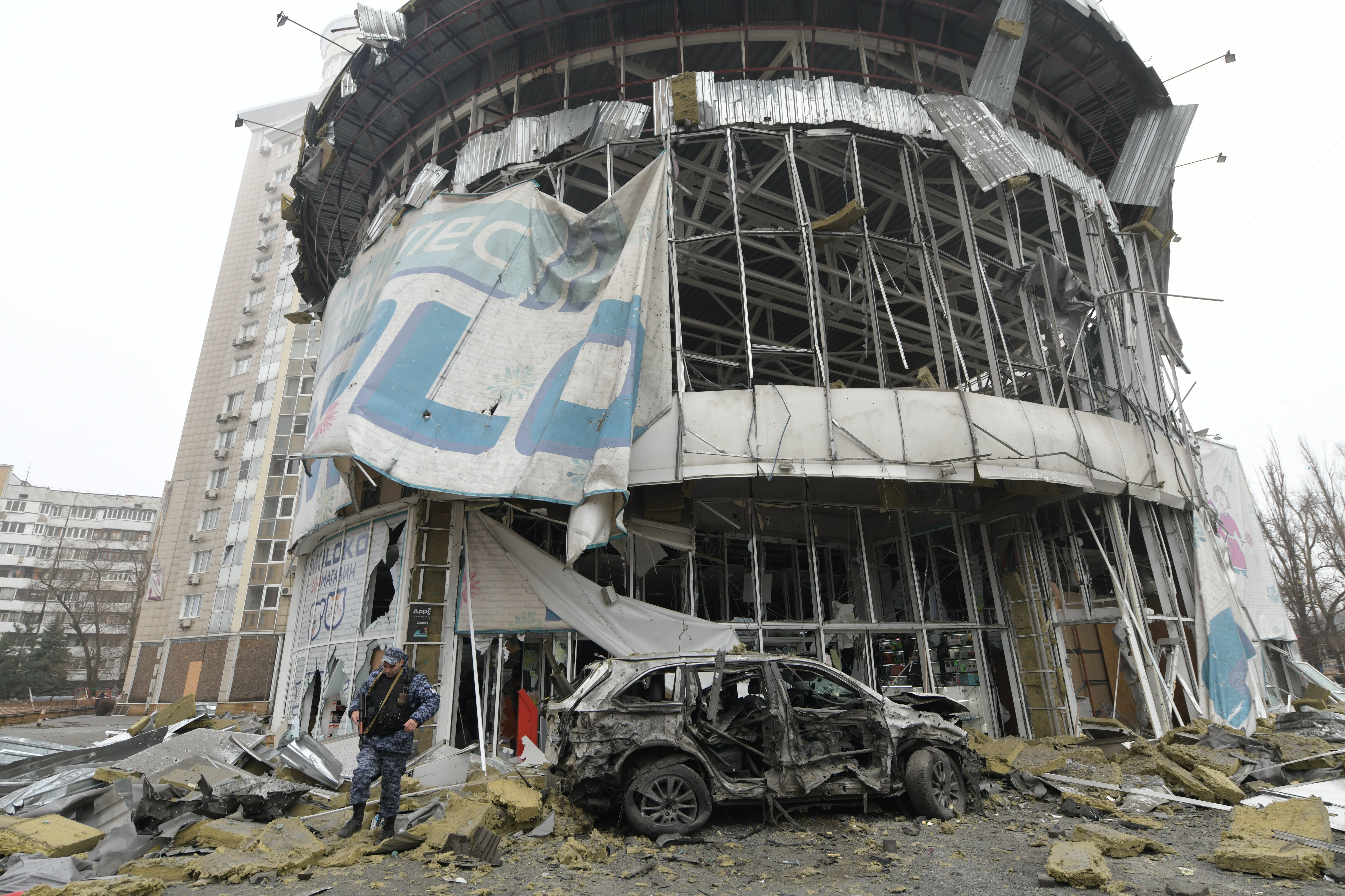 A law enforcement officer walks near a damaged store following shelling, which local officials called a Ukrainian military strike in Donetsk