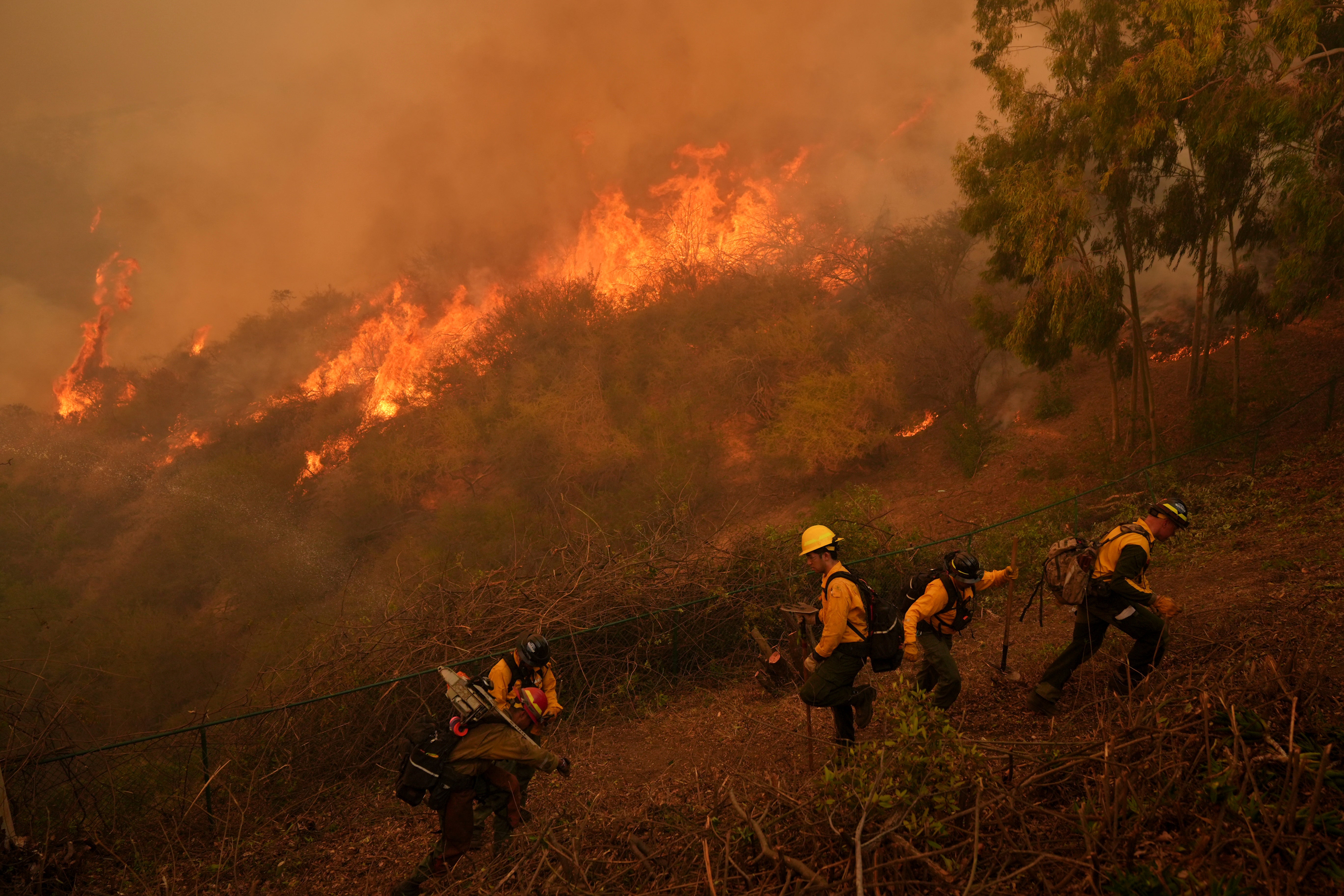 Fire Crews battle the Palisades Fire in Mandeville Canyon in Los Angeles, California, on Saturday. Forecasters warned of more dangerous critical fire weather this week