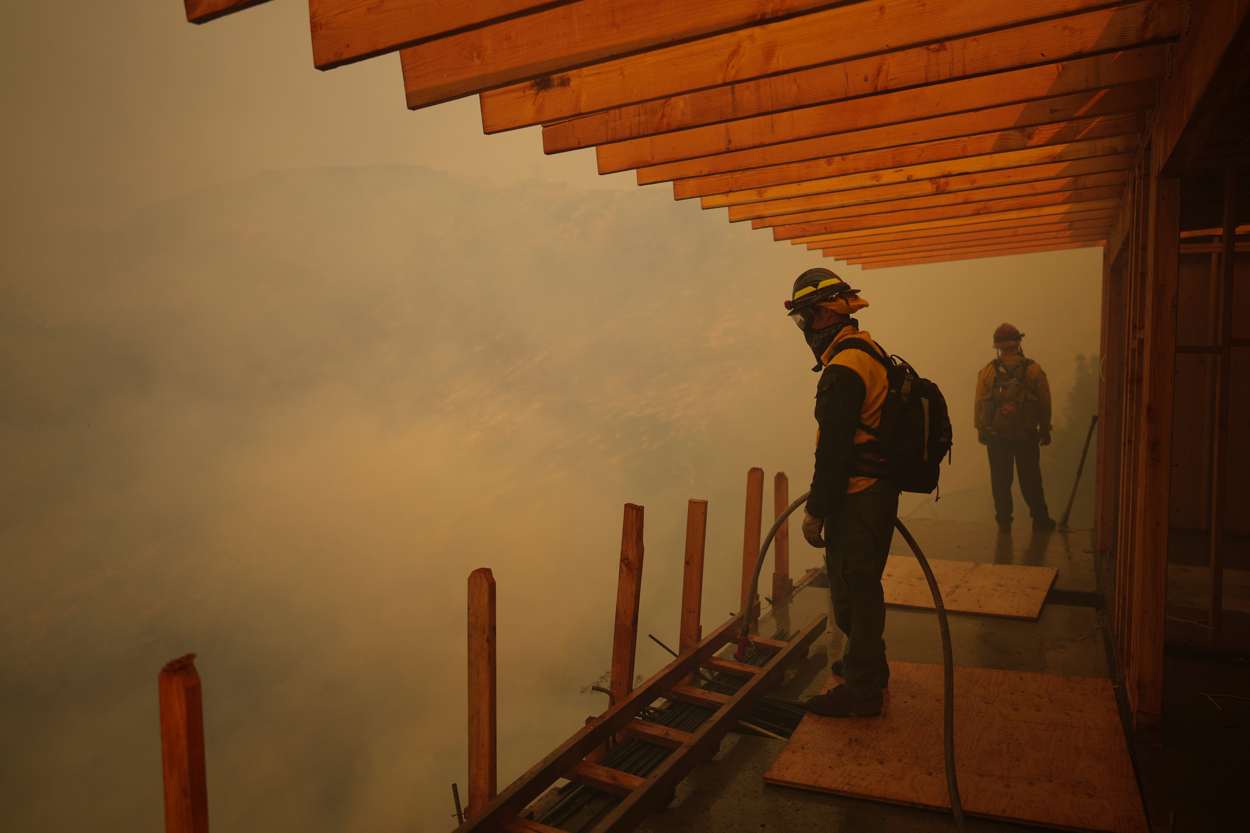 Firefighters monitor the advance of the Palisades Fire in Mandeville Canyon in Los Angeles, California, on Saturday. More than 14,000 personnel have been deployed to respond to the Southern California fires