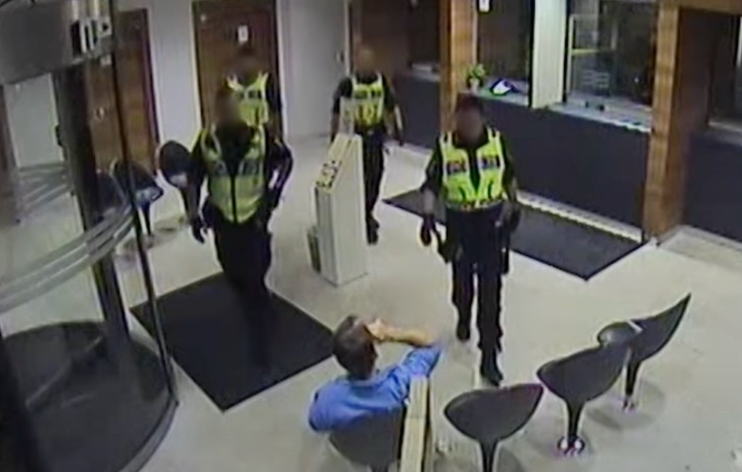 Police move in as the doctor casually drinks in the police station waiting room