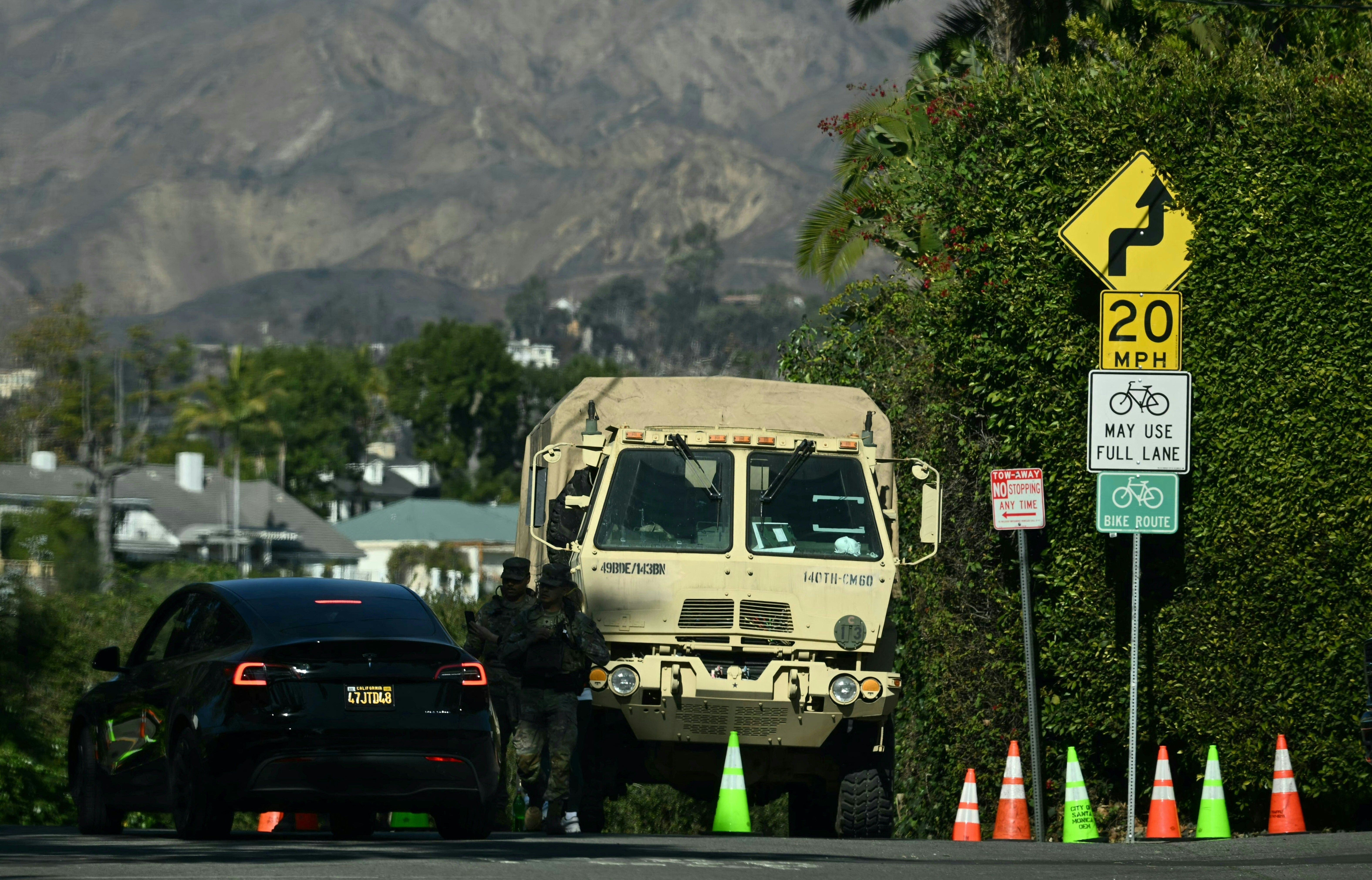 Members of the National Guard block a road on the border of Santa Monica and Pacific Palisades on Monday in Los Angeles, California. Thousands of members have deployed throughout the region