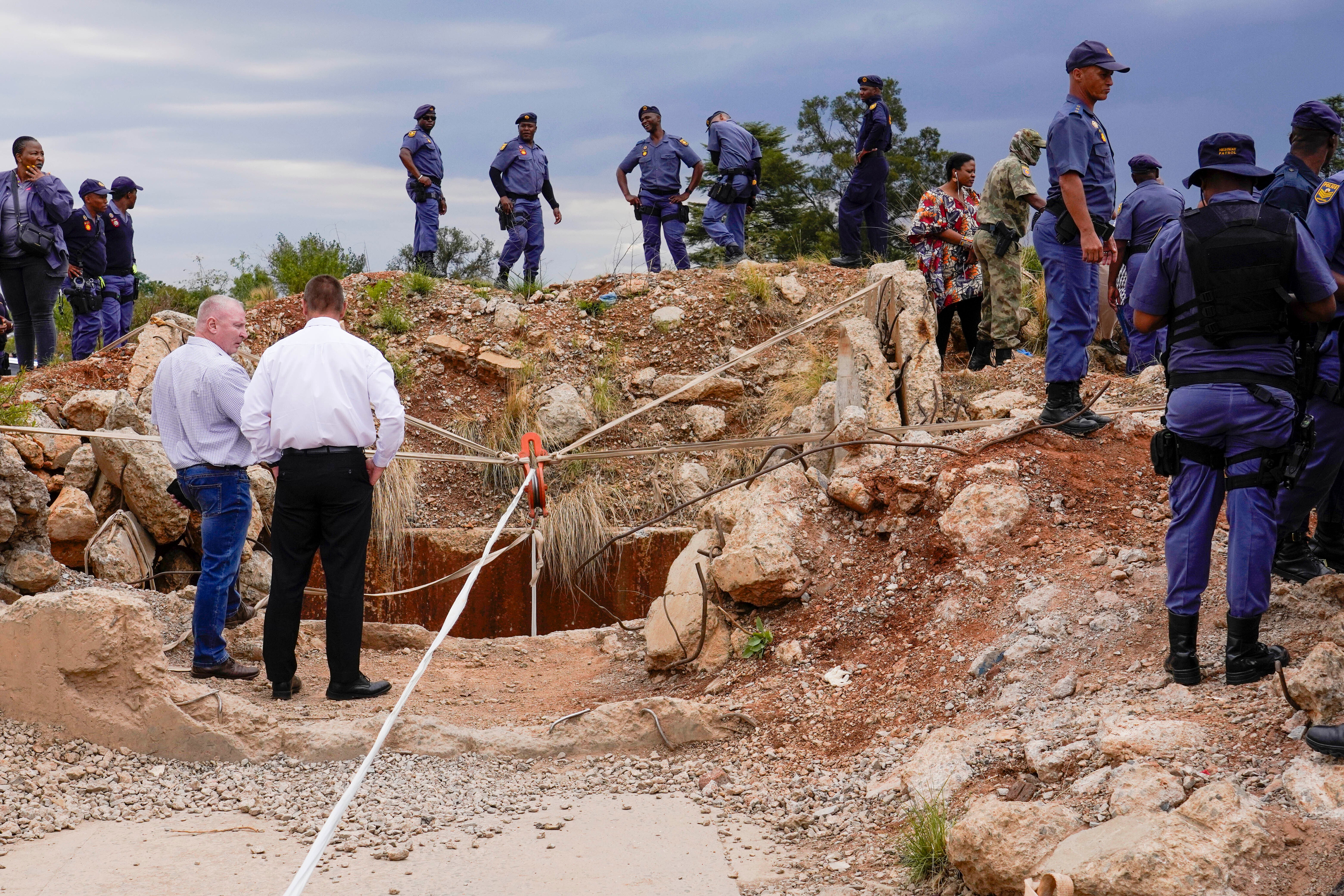 Police officers and private security personnel stand by the opening of a reformed gold mineshaft where illegal miners are trapped in Stilfontein, South Africa