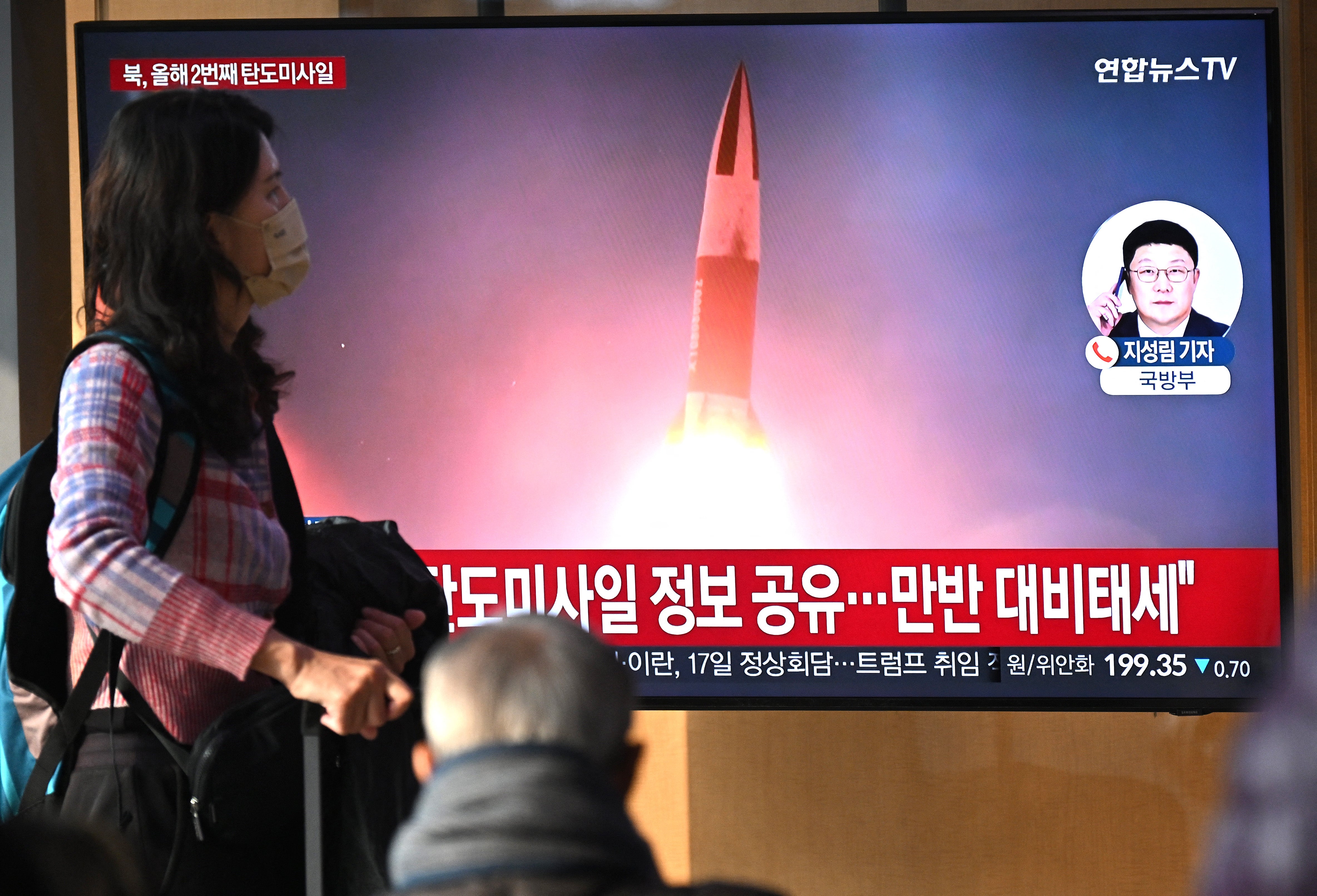 <p>A TV news broadcast shows file footage of a North Korean missile test at a train station in Seoul on 14 January 2025</p>