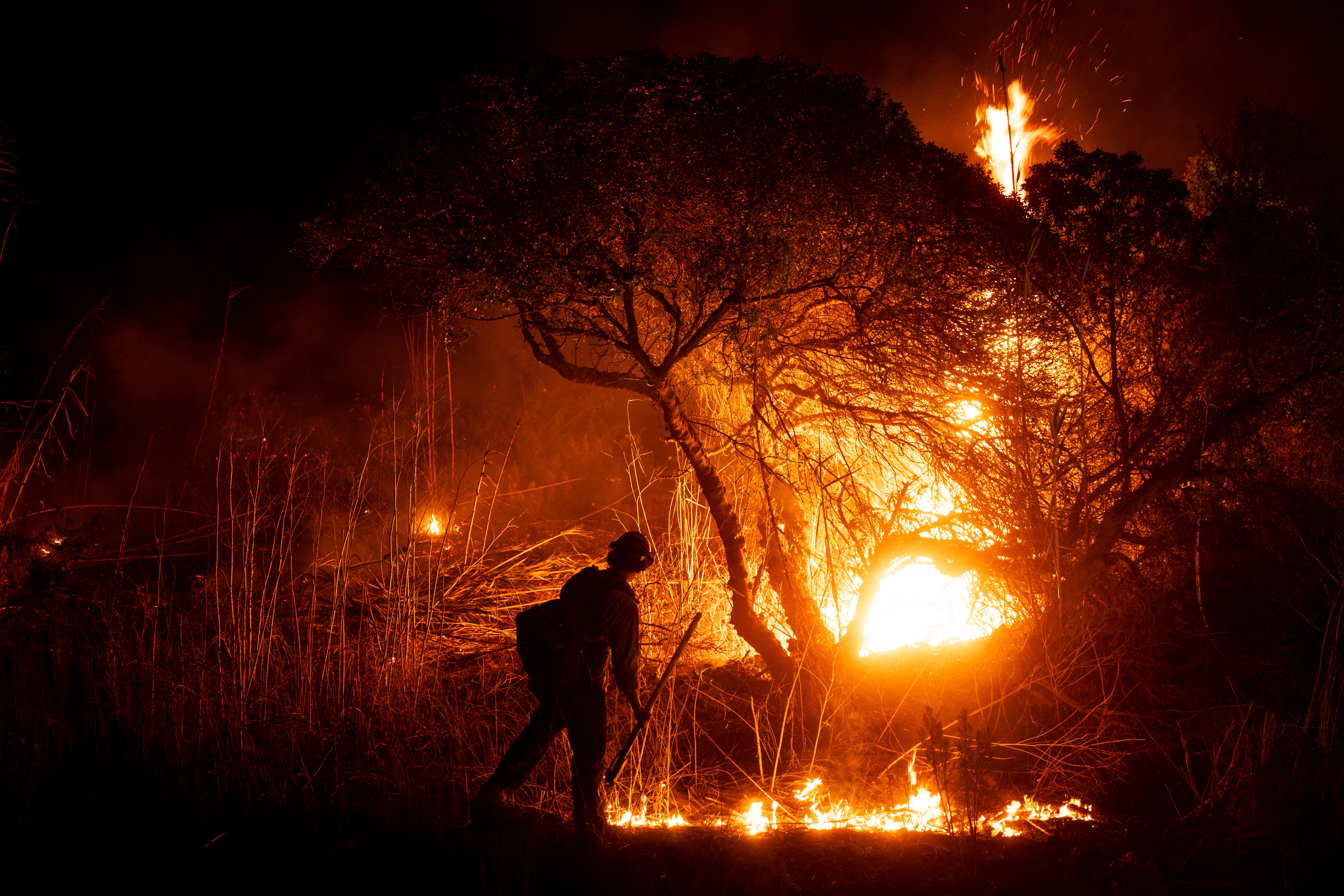 A firefighter monitors the spread of the Auto Fire in Oxnard, northwest of Los Angeles, California, on January 13