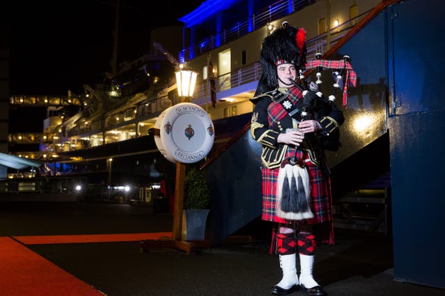 <p>A piper outside the royal yacht Britannia in Edinburgh</p>