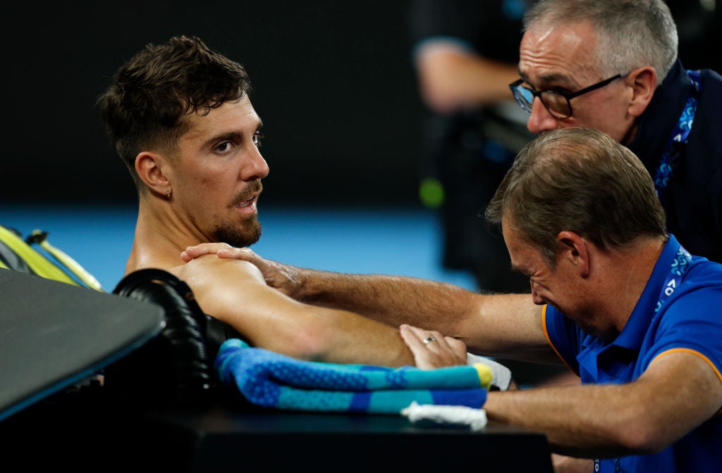 Thanasi Kokkinakis receives medical treatment during his match against Draper