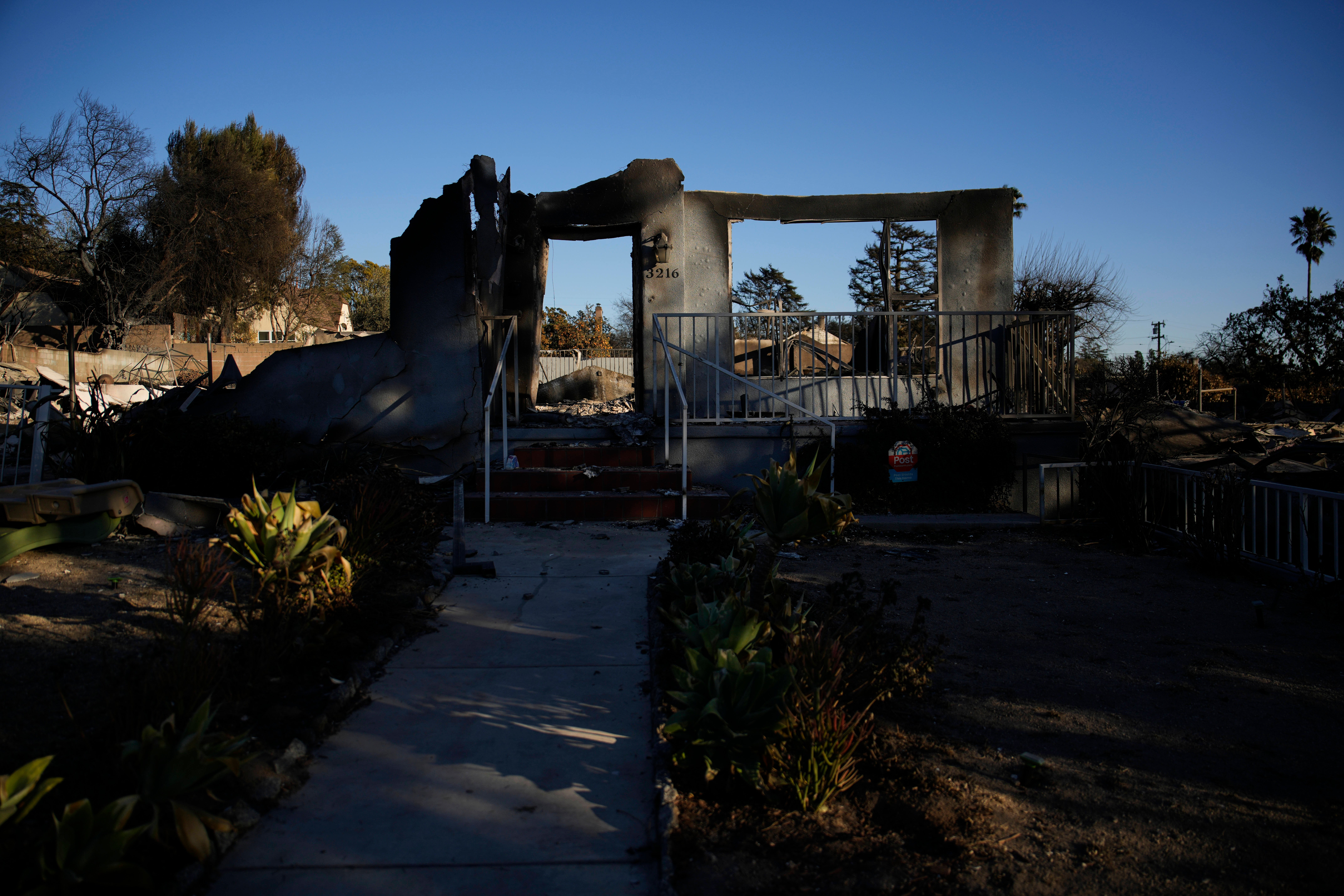 Part of a home destroyed by the Eaton Fire still stands on Tuesday in Altadena, California. Residents have returned to rubble